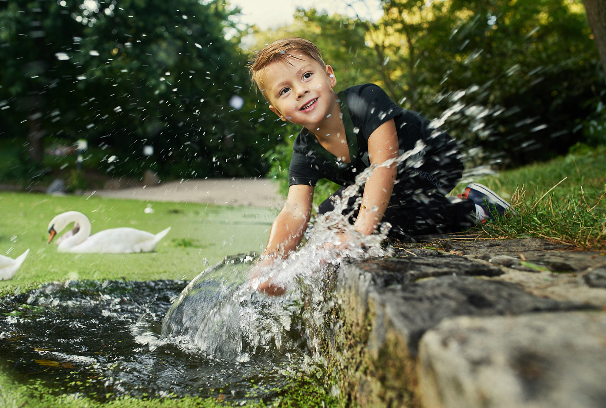 Cheerful and engaging child photography featuring water play  with splashes at Prospect Park, Brooklyn, NY.