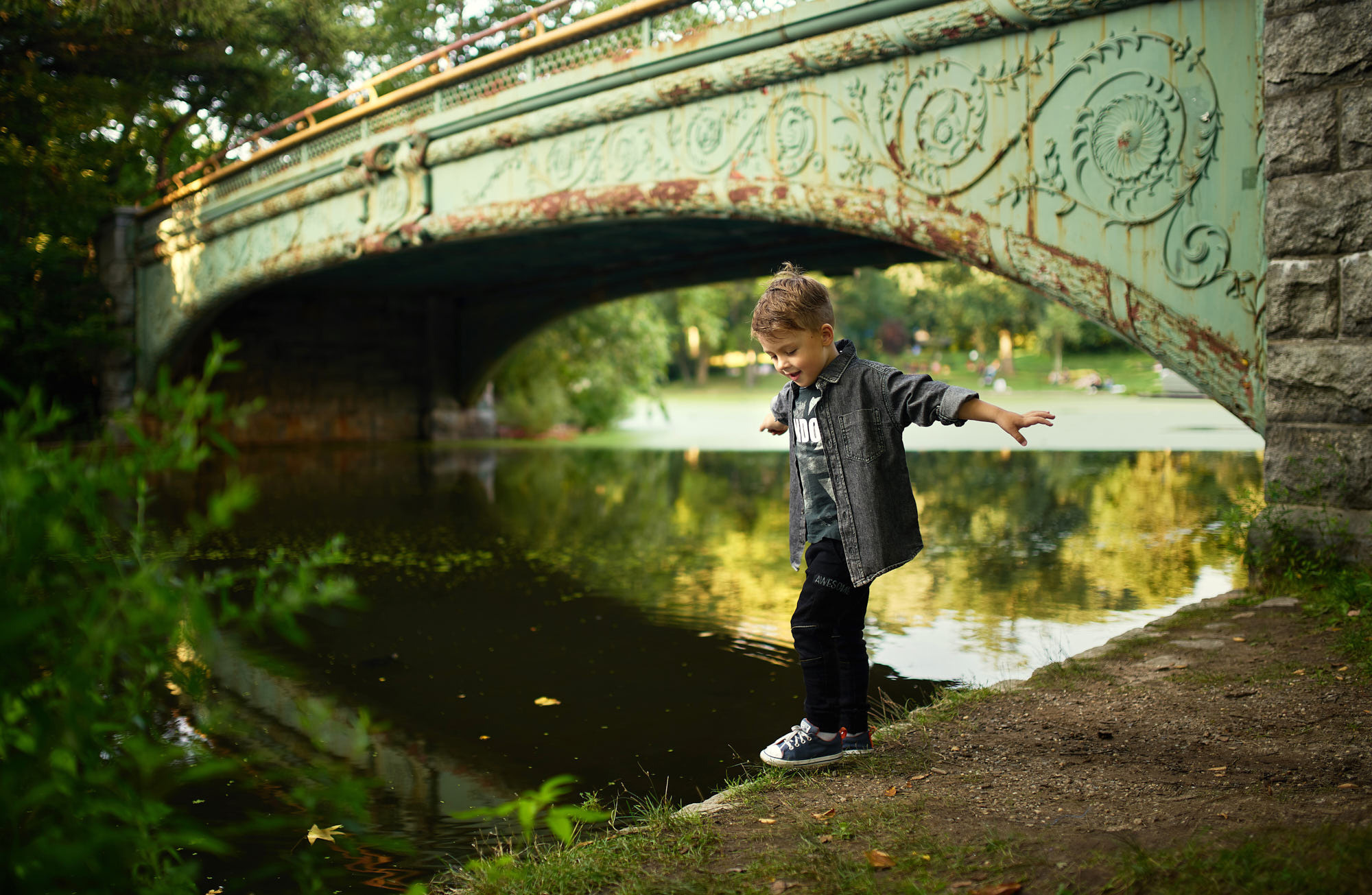 Artistic child photography featuring a boy behind the bridge at Prospect Park, Brooklyn, NY.