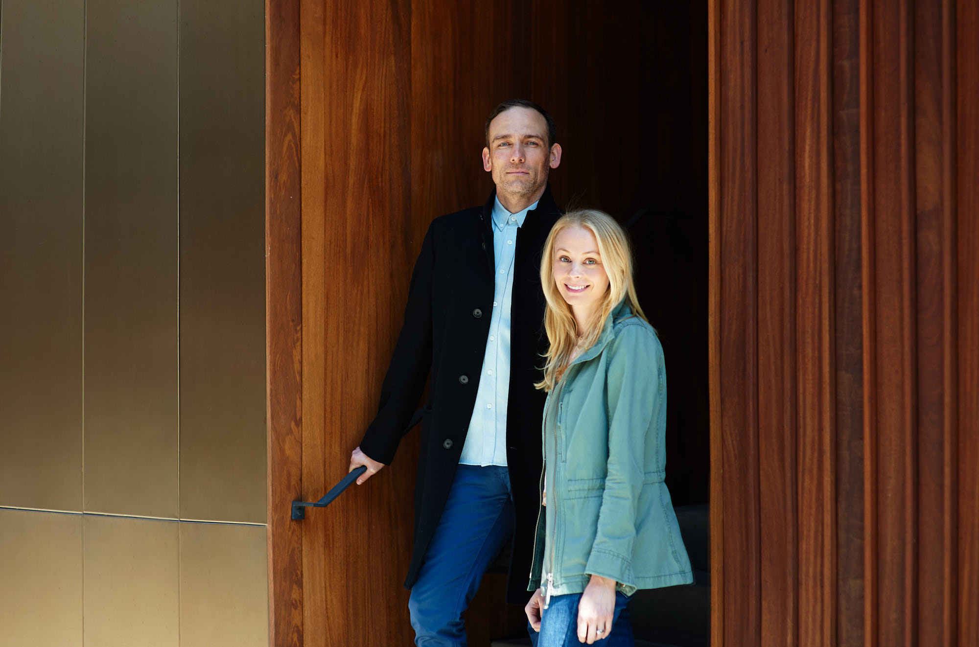 Modern family couple coming out of the stylish building in Dumbo, Brooklyn, NY