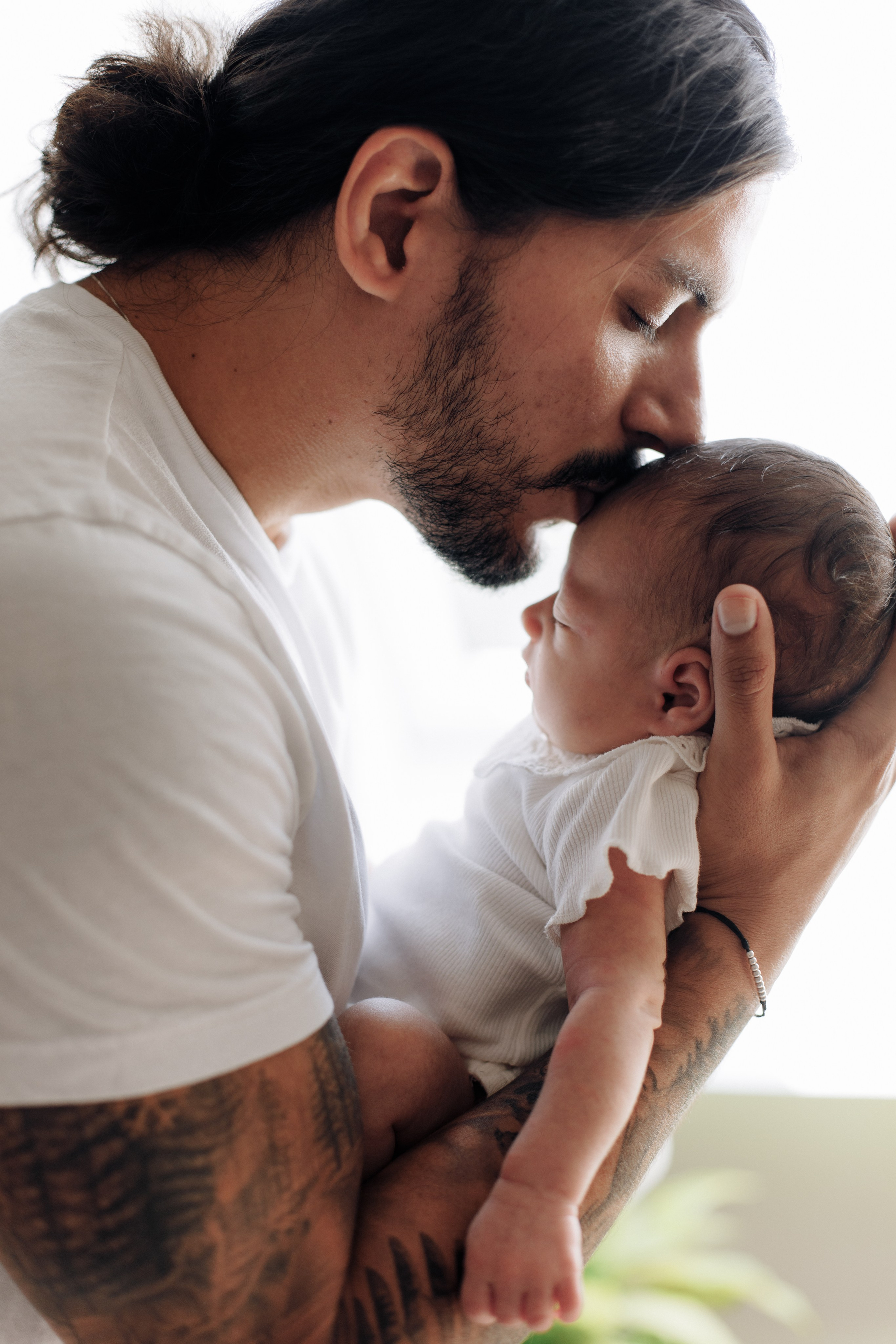 Vater küsst seine schlafende Tochter sanft auf die Stirn.
