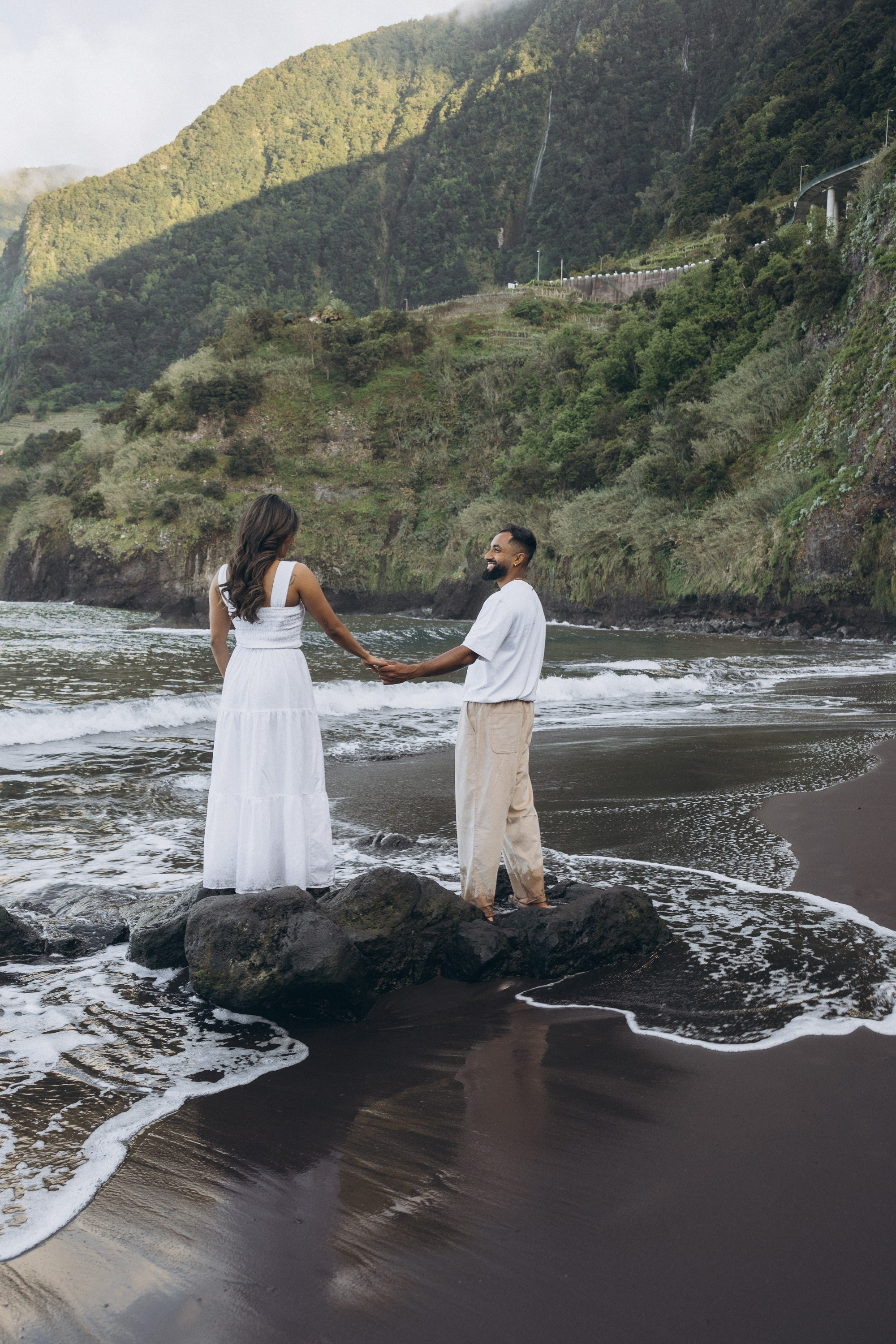 Romantic proposal on Seixal Beach, Madeira — black sand and ocean waves.