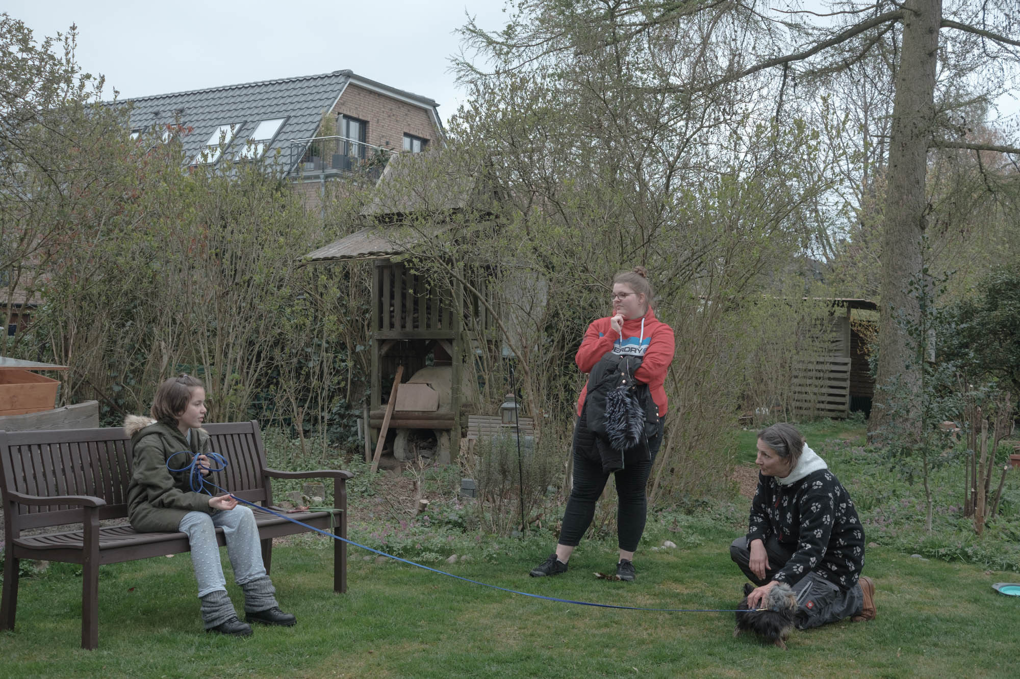 Sabrina talks with neighbors Sylvia in the garden while walking her dog Richard, April, 2022