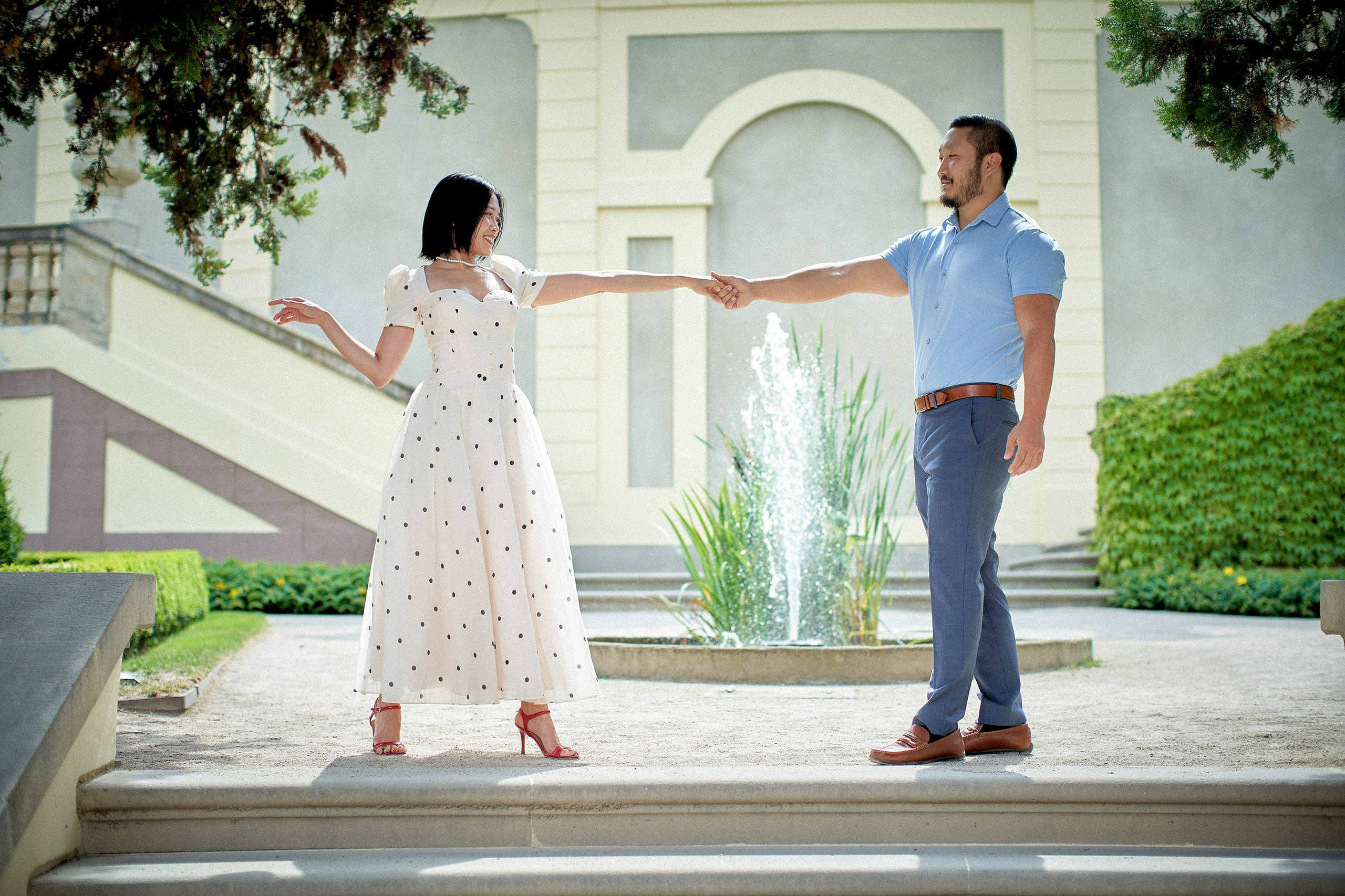 Man taking his fiancée's hand during a romantic moment in Prague's Vrtba Garden.