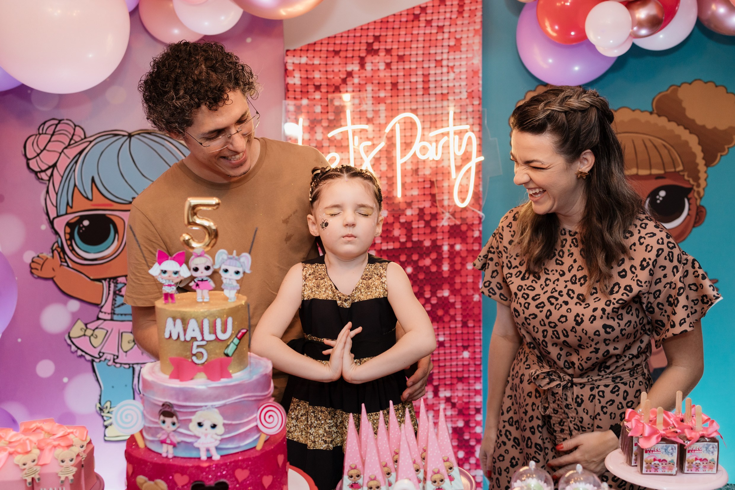 Menina fazendo pedido antes de soprar a vela do aniversário