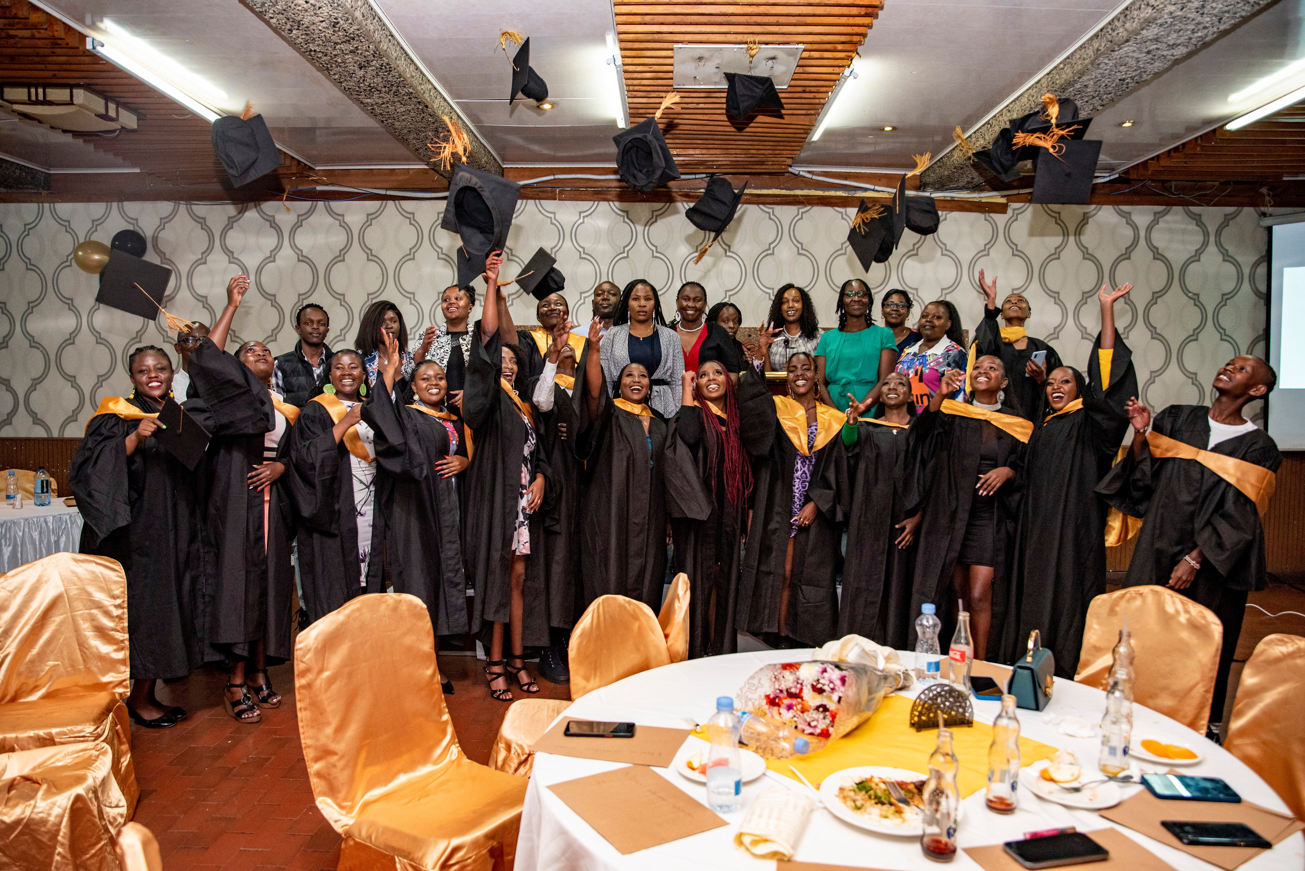 Graduates toss their graduation caps in the air in celebration after their graduation ceremony 