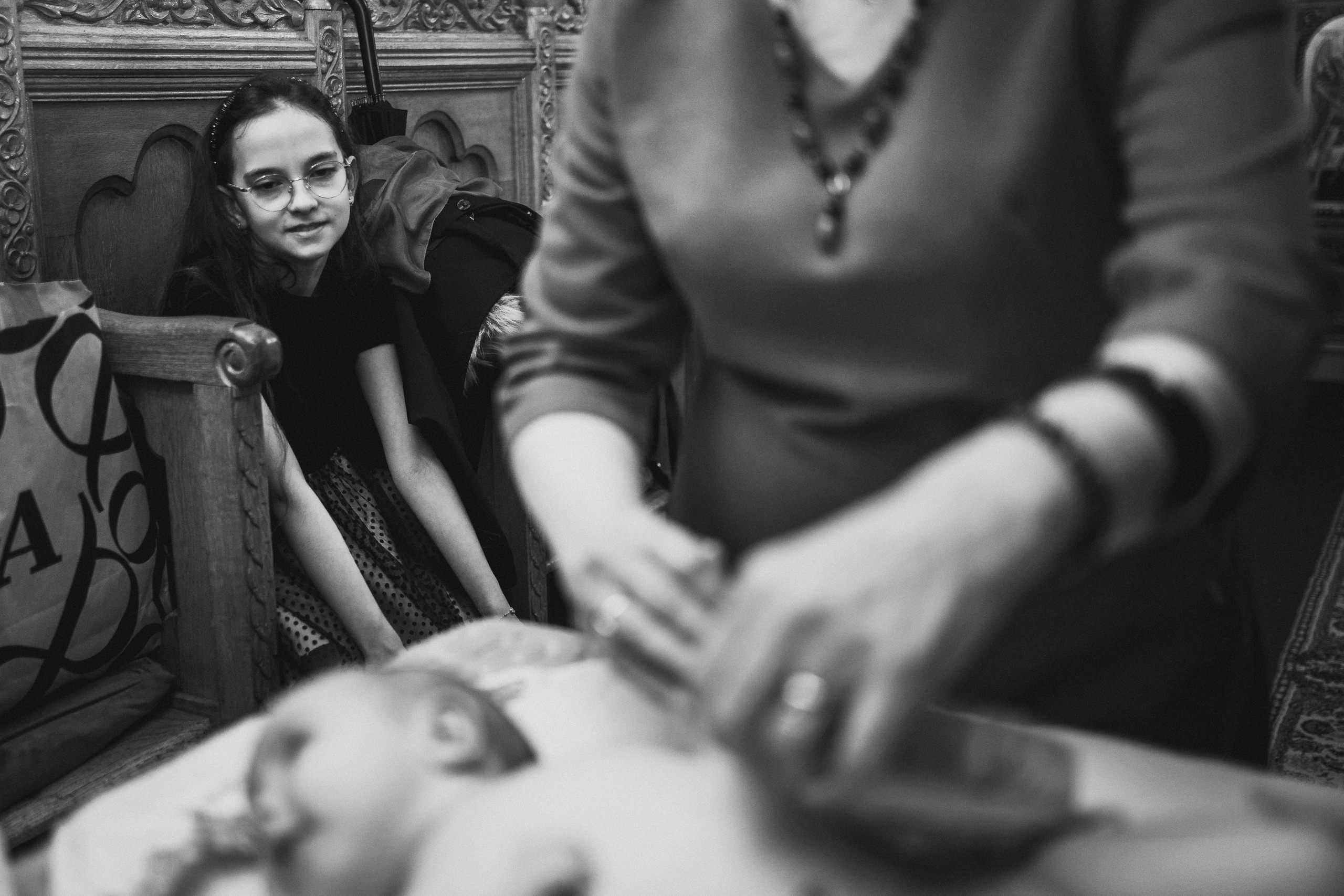 Instantaneu plin de tandrețe dintre părinți și bebeluș în ziua botezului, realizat în Bucuresti. Fotografie profesională de botez, capturând emoțiile autentice ale familiei într-un decor luminos și cald