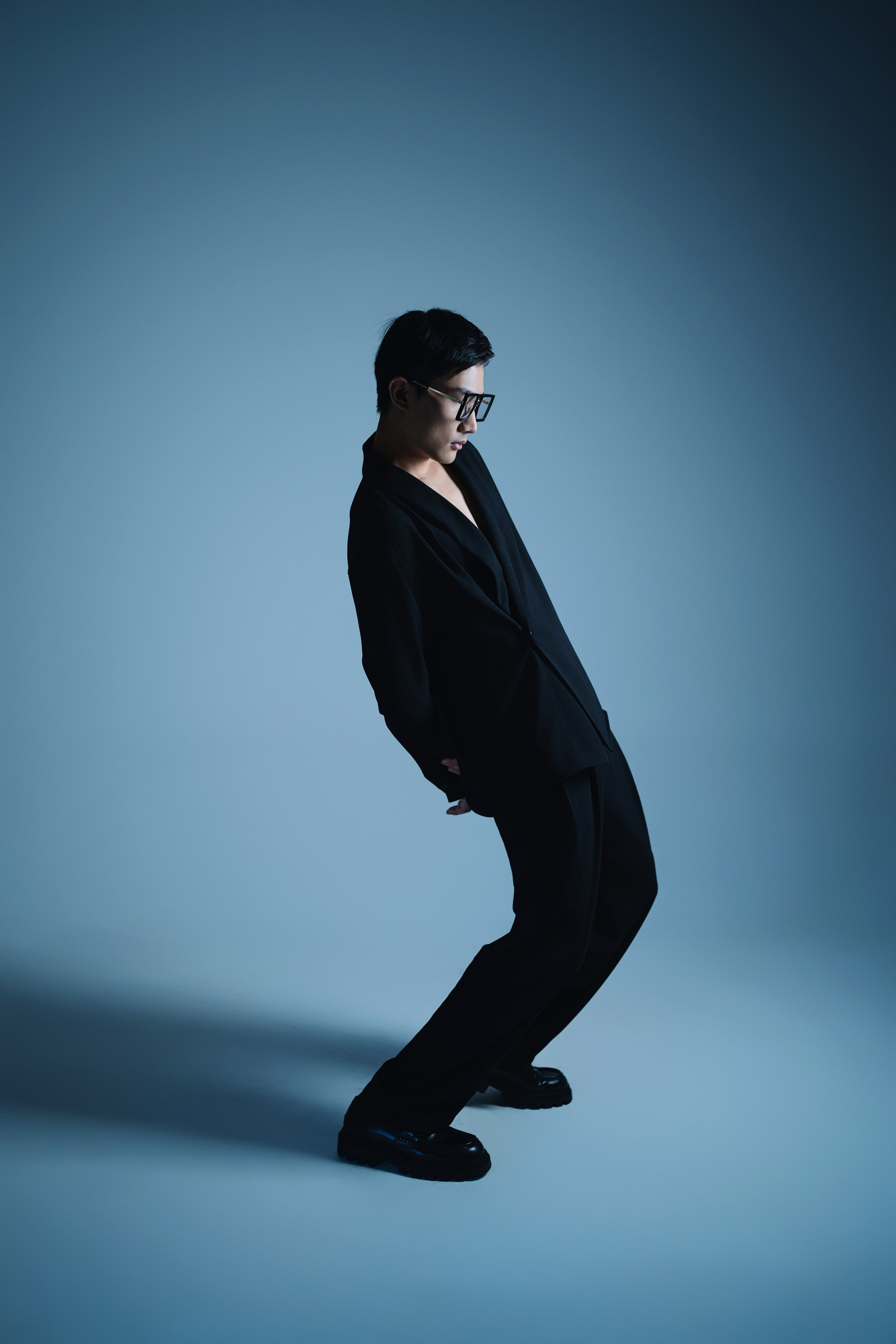 Studio Fashion Portrait with Bold Backlighting – A model posing in a dramatic fashion portrait with bold backlighting that creates a halo effect around her, emphasizing her figure and the clean, modern styling of the shoot.