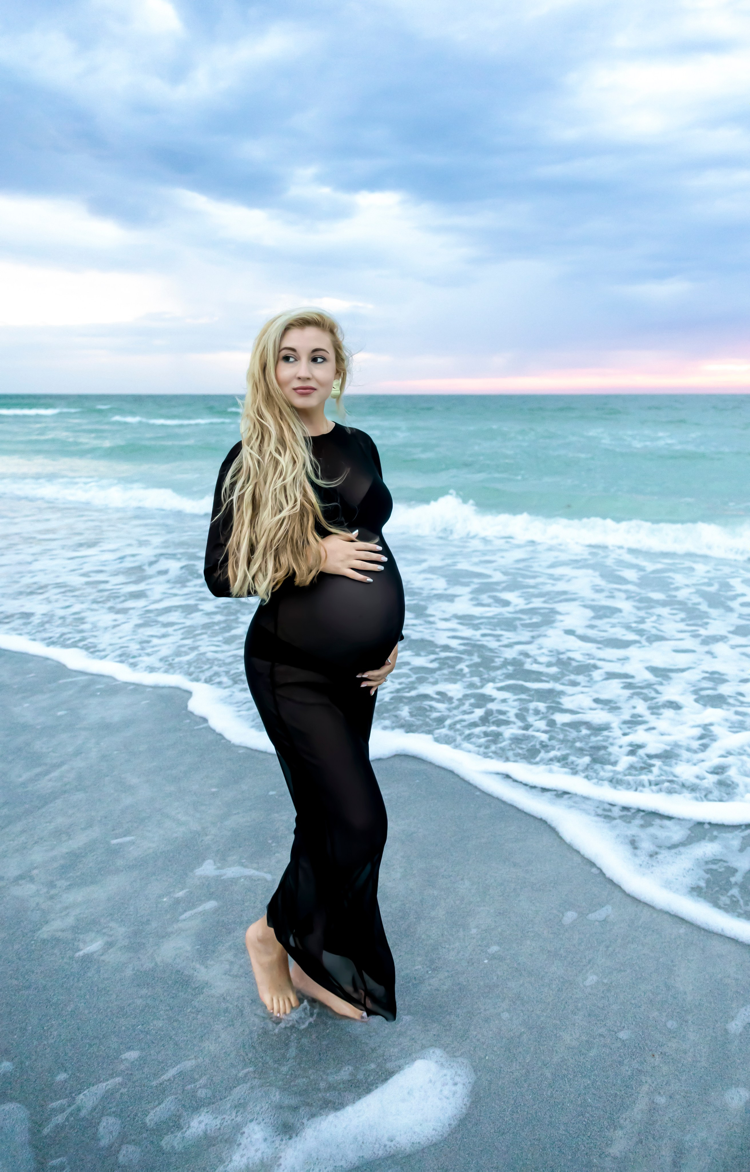 woman in the black chiffon maternity dress on the beach