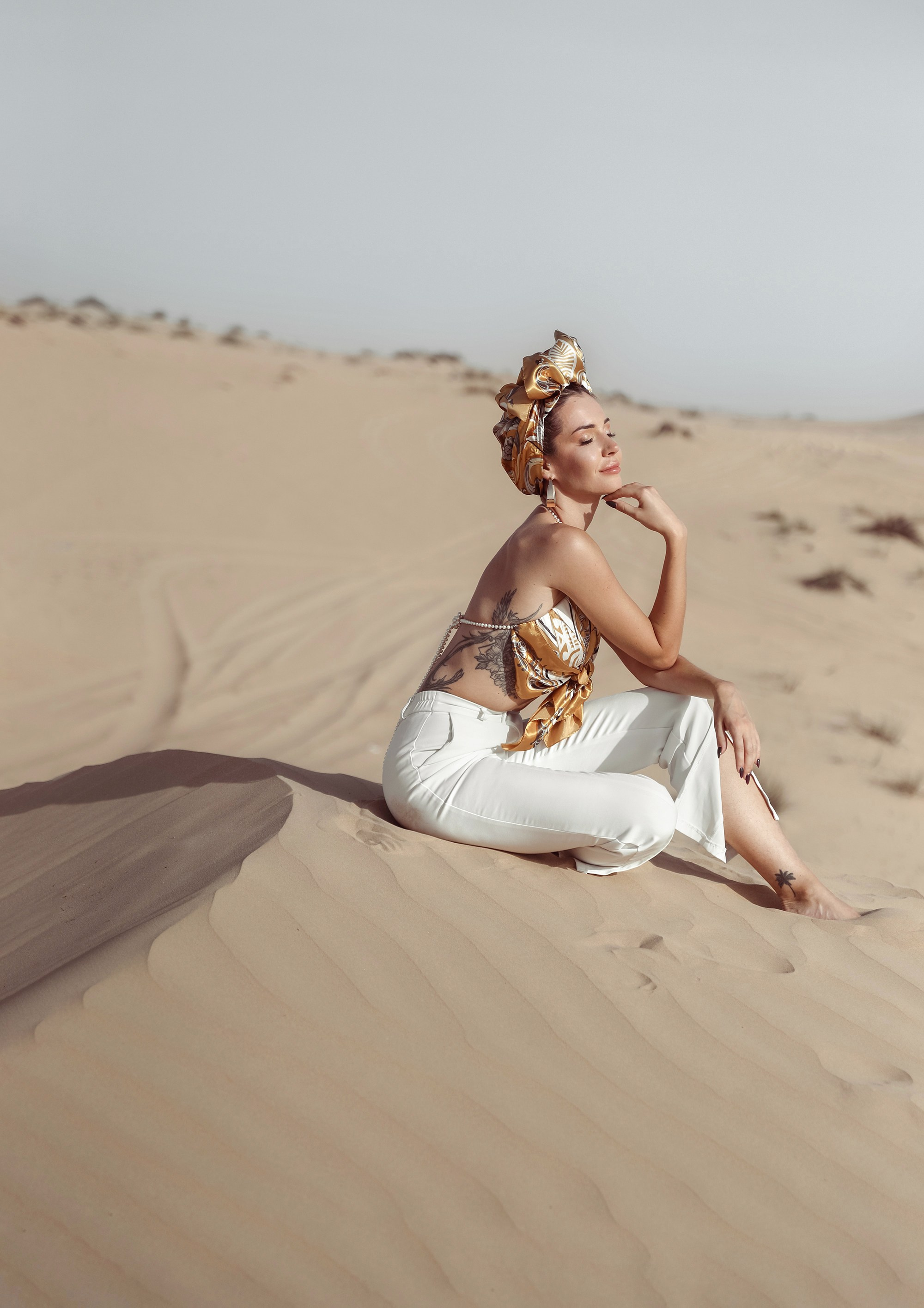 A breathtaking portrait of a woman in the desert, her natural beauty accentuated by the soft, golden tones of the sand and sky. Dubai, United Arab Emirates