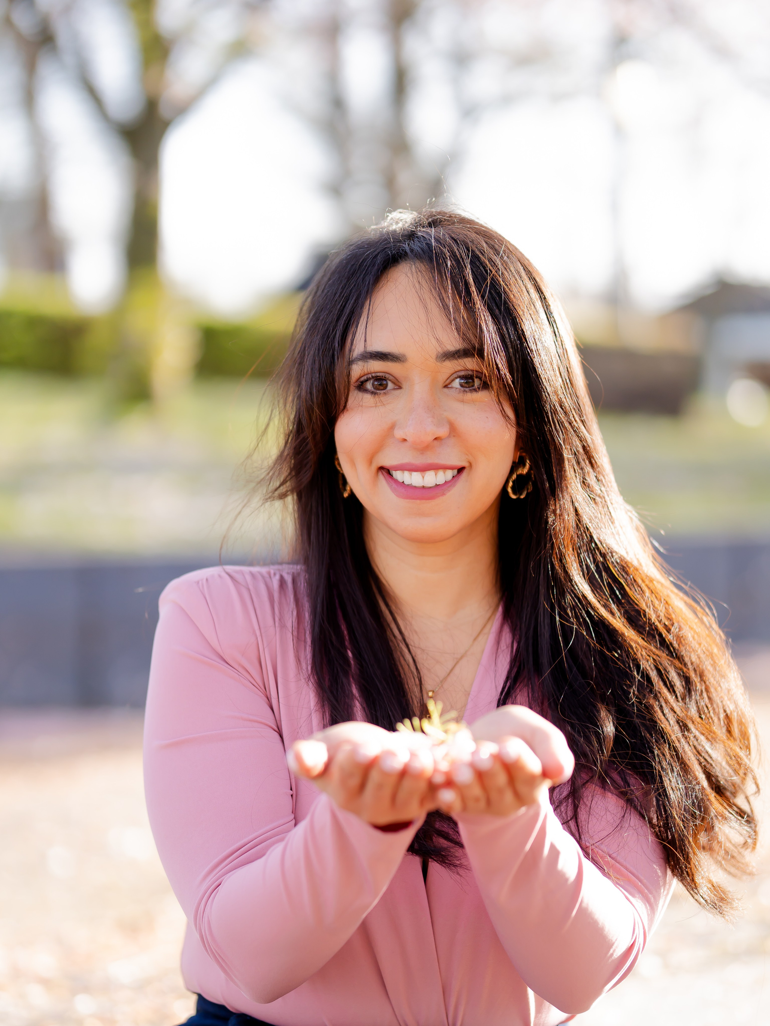 Woman holding petals of cherry blossom flowers