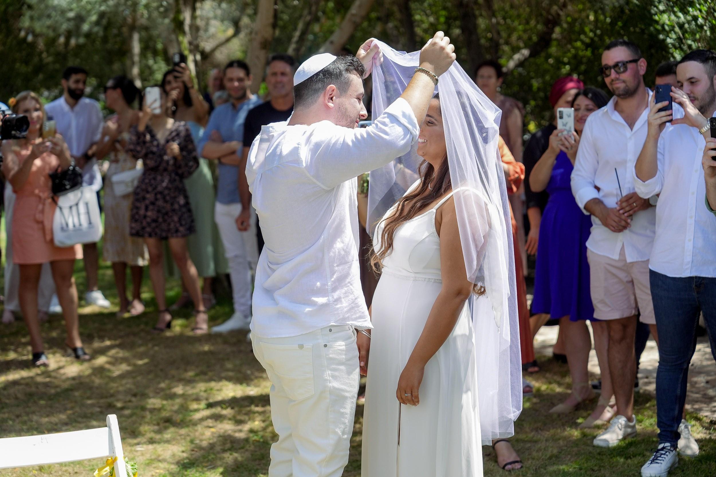 Ronen places the veil over Talia during the bedeken ceremony