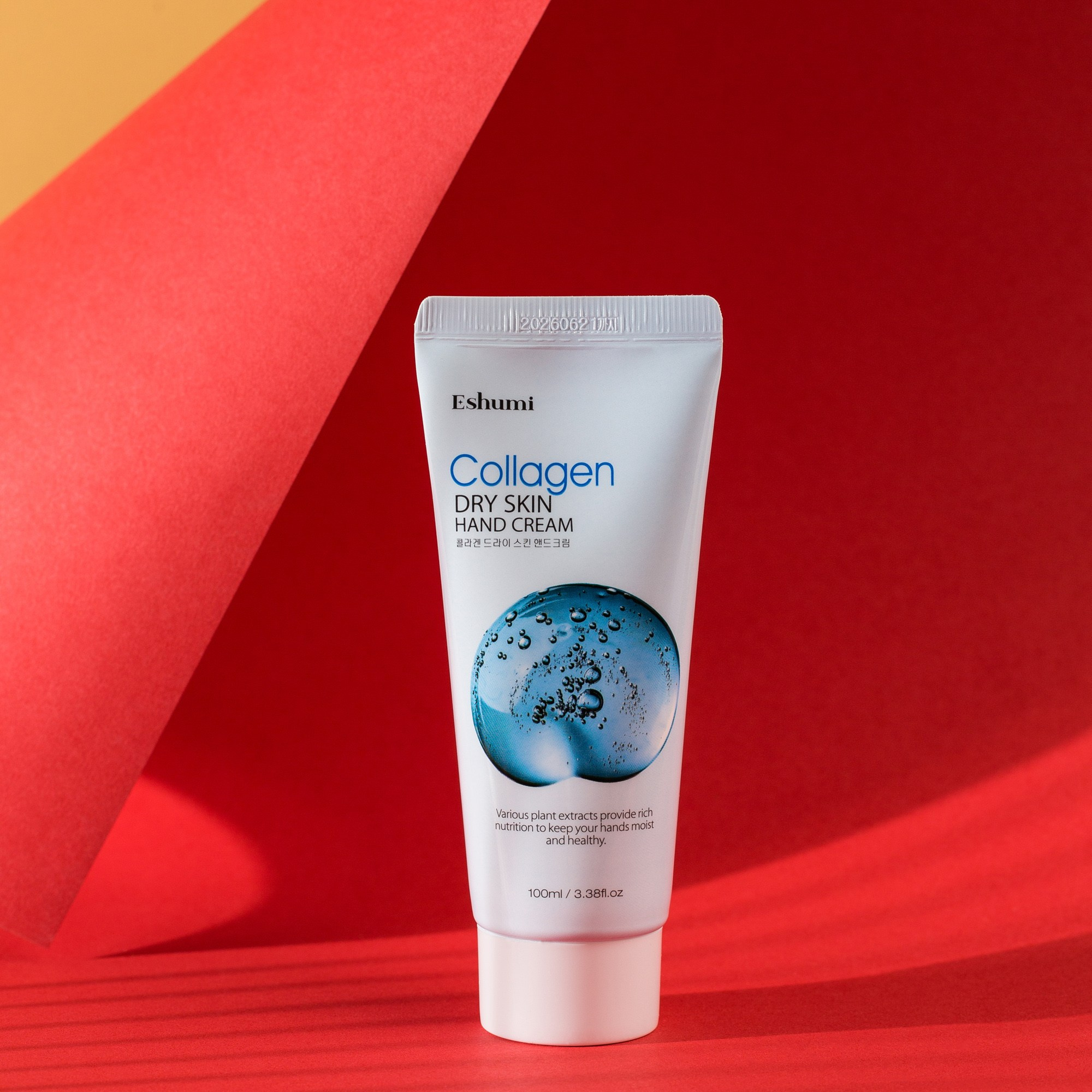 Eshumi Collagen Hand Cream, qırmızı və sarı fon arasında işıq kölgə effekti ilə minimalistik məhsul fotoşəkili.