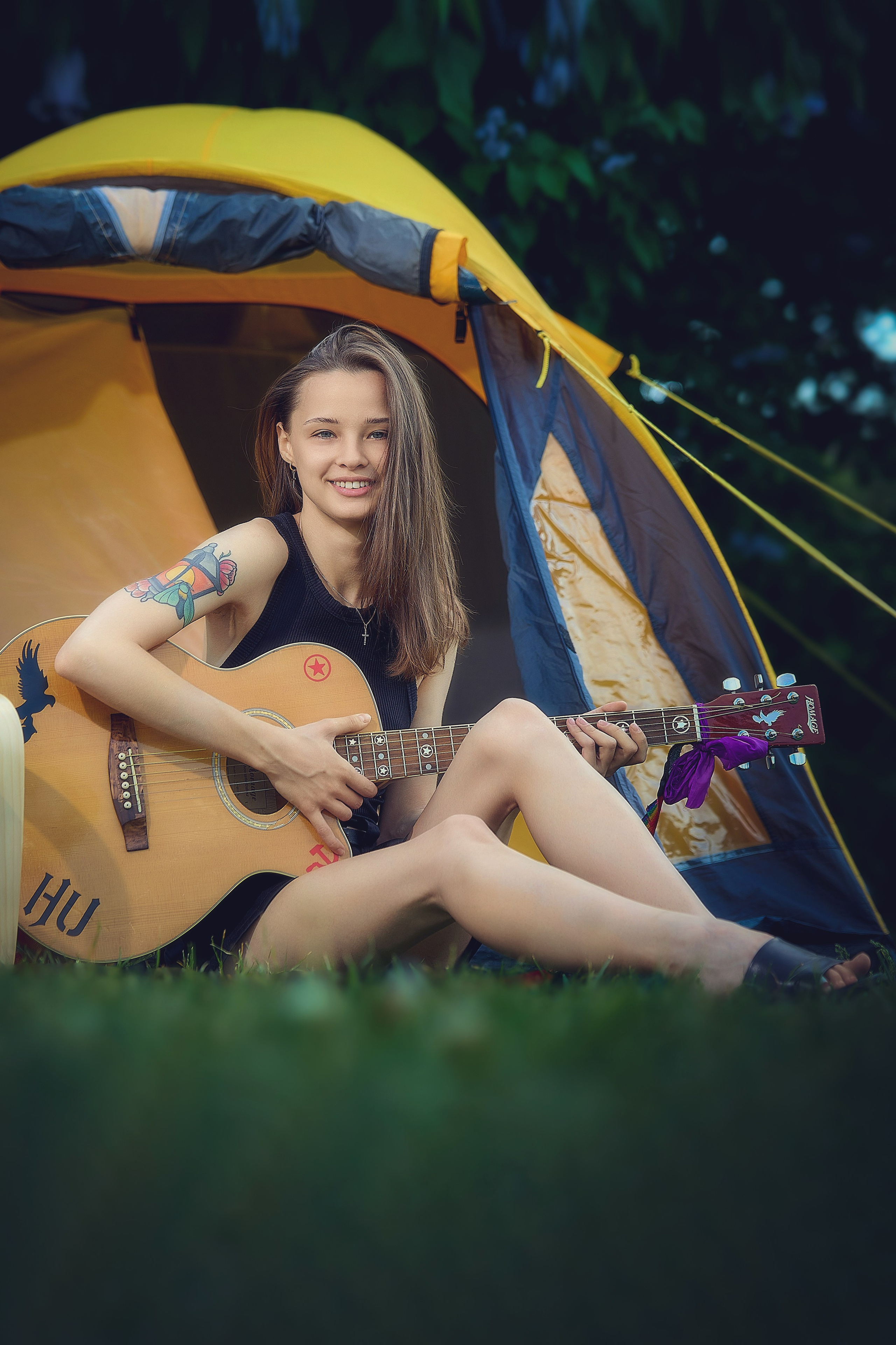 Уличная фотосесия красивая девушка с гитарой на лугу у палатки