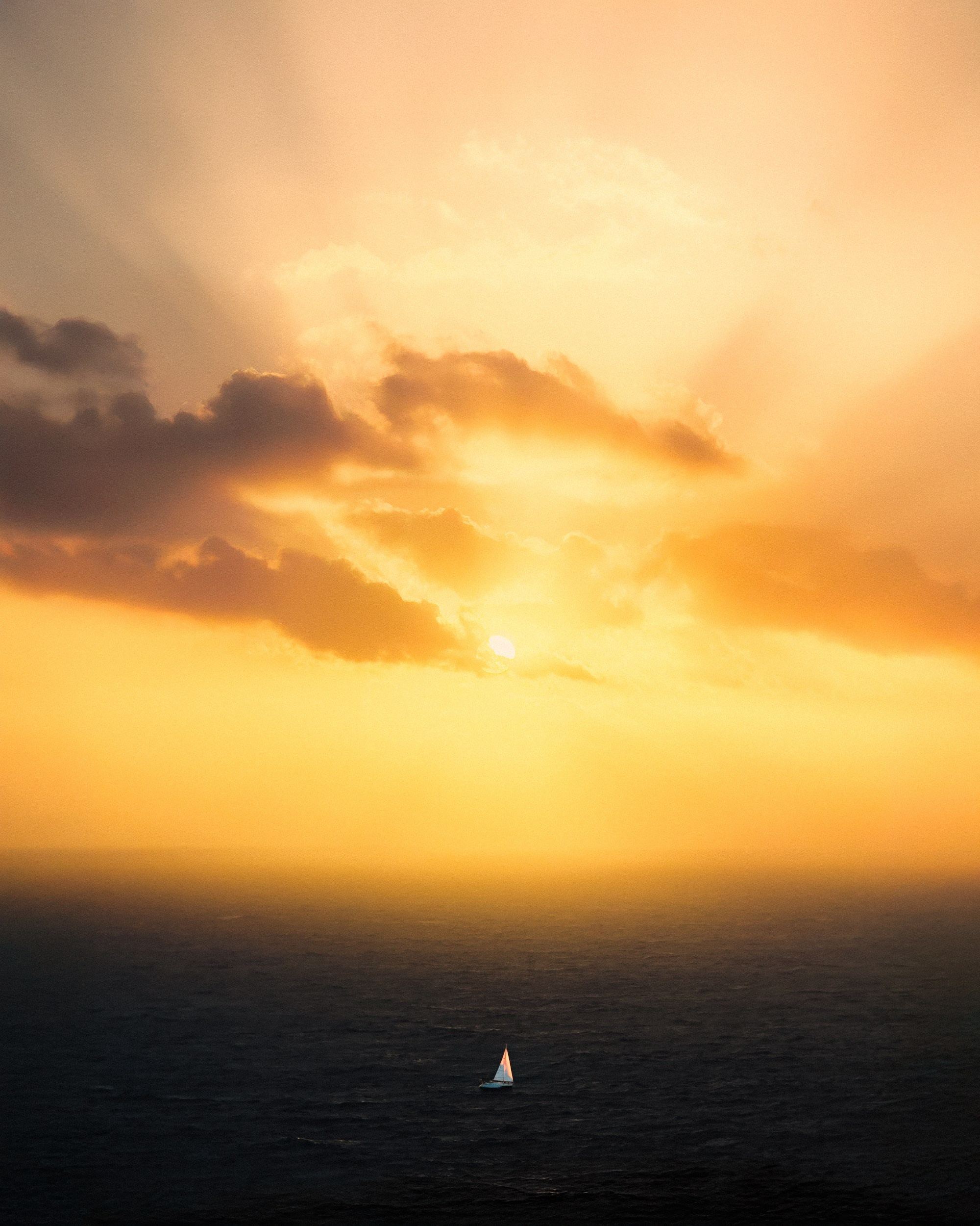 A drone photo of the ocean sunset with a small boat in Cyprus 