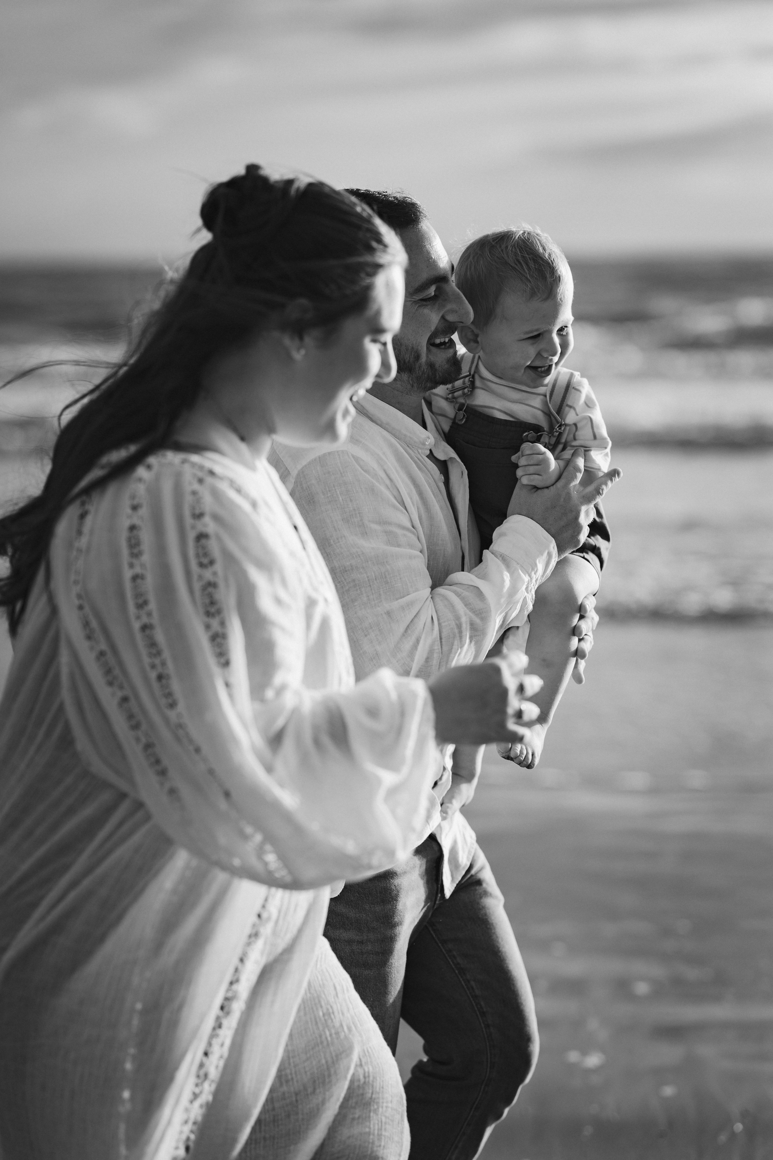 Famille jouant sur la plage au coucher du soleil, photos naturelles pleines de mouvement