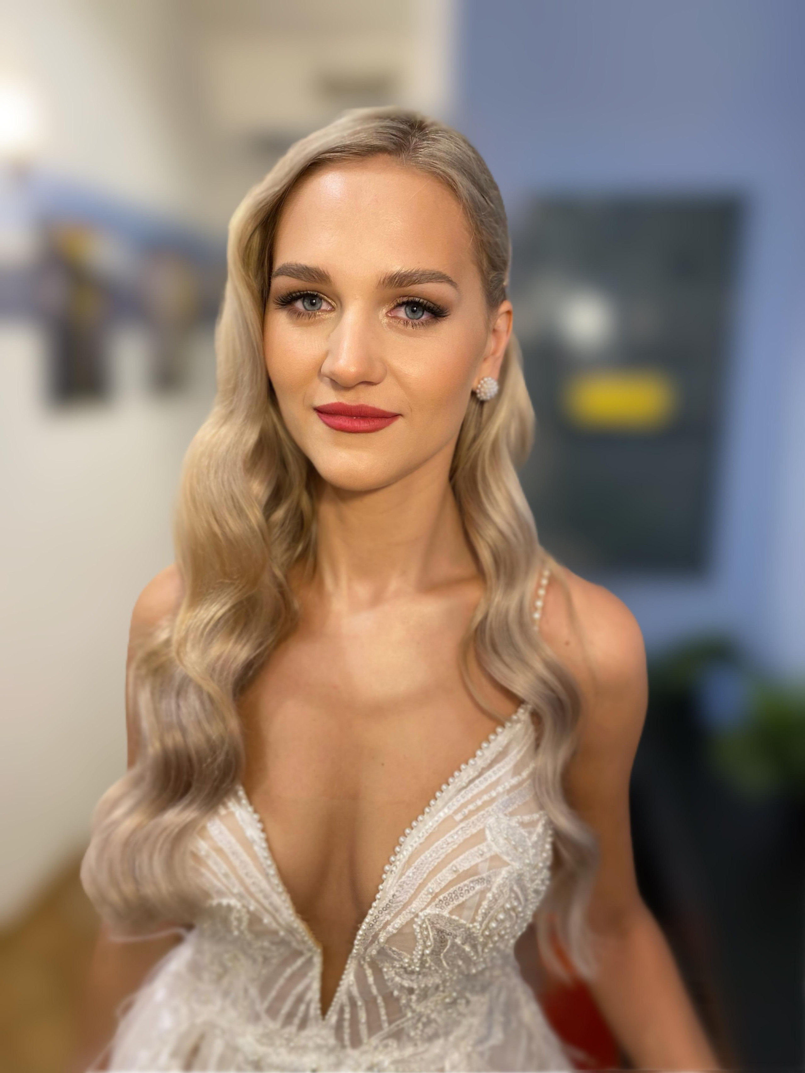 hollywood hairstyle on blond bride with extebsions and soft glam makeup in a hostel room