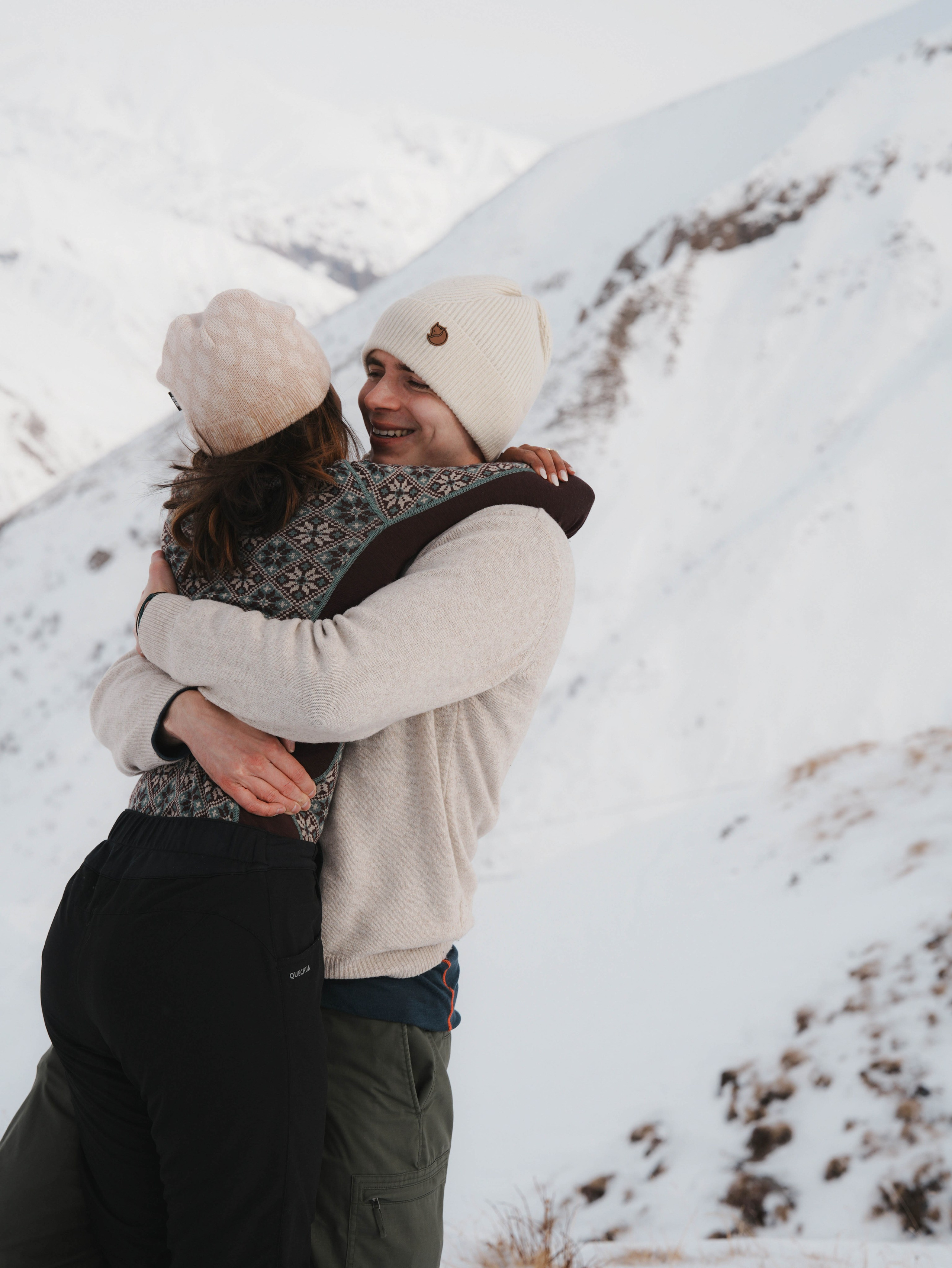 Couple hugging on snowy slope in Georgia