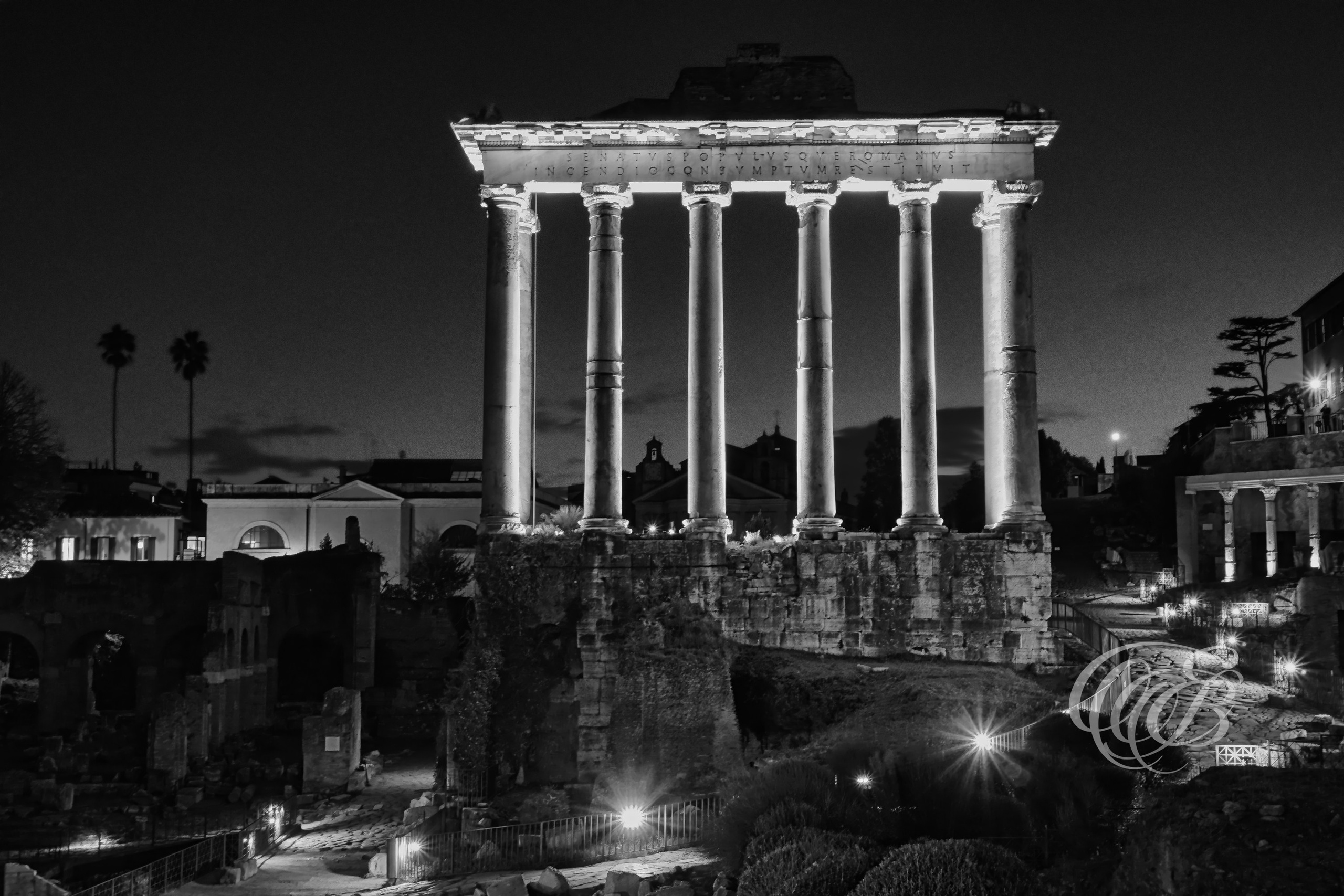 Rome, Italy – The Roman Forum near night – B&W – Eduardo Bartoli Fine Art Photography – Black and white photograph of the six surviving columns of the Temple of Saturn in the Roman Forum under a darkening twilight sky.
