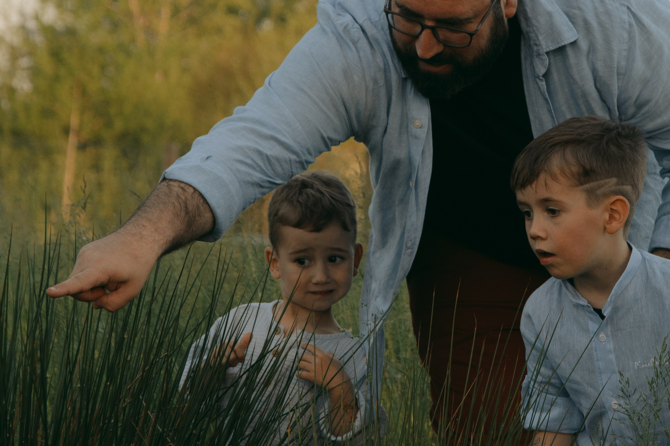 Childrens play in the park in Milan. Finding frogs with thei father. Private photoshooting of family