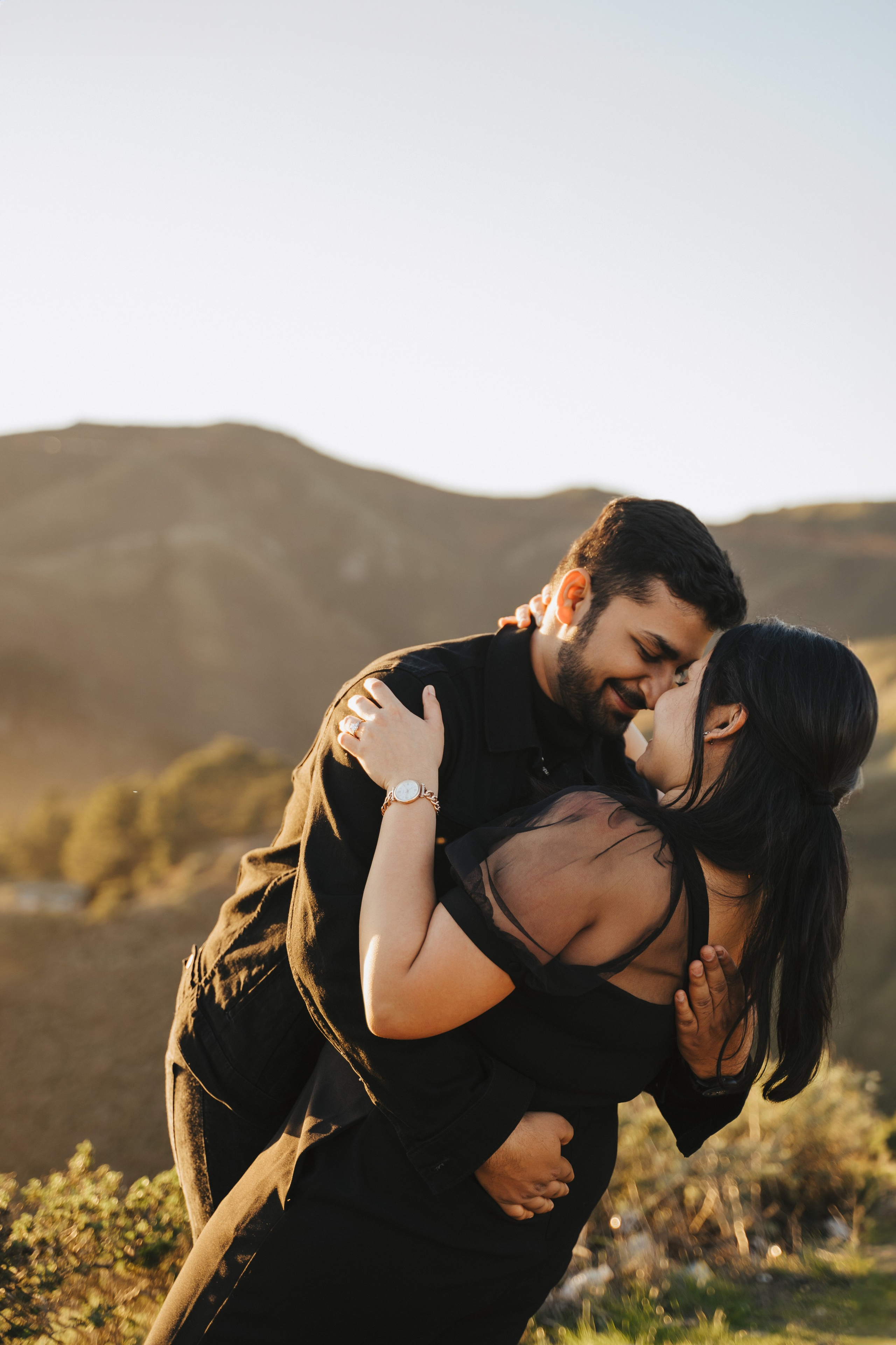 Proposal.  Overlooking the golden San Franisco Bridge sunset with a couple. Photographer Video. 
