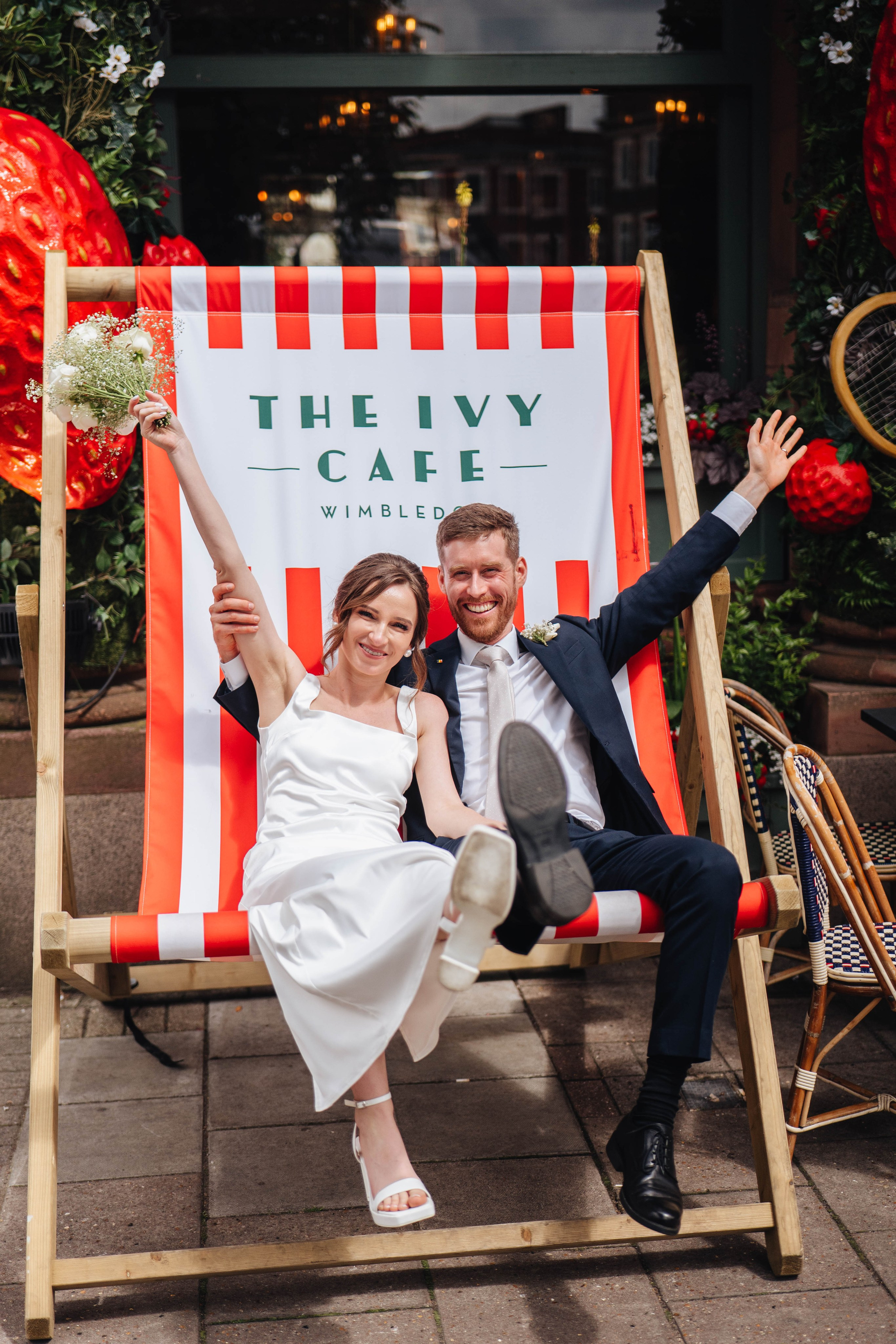 bride and groom sitting in the large chair near the restaurant