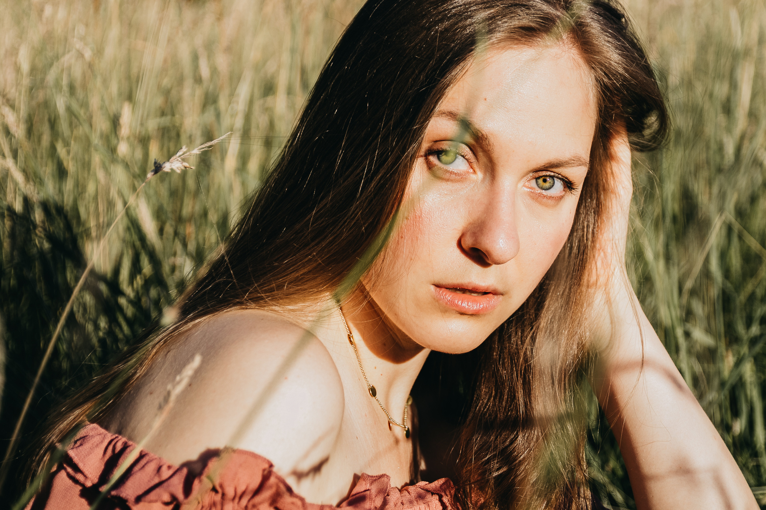 Porträt einer jungen Frau im Abendlicht – natürliche Outdoor-Aufnahme während einer Portrait Session im Grünen.