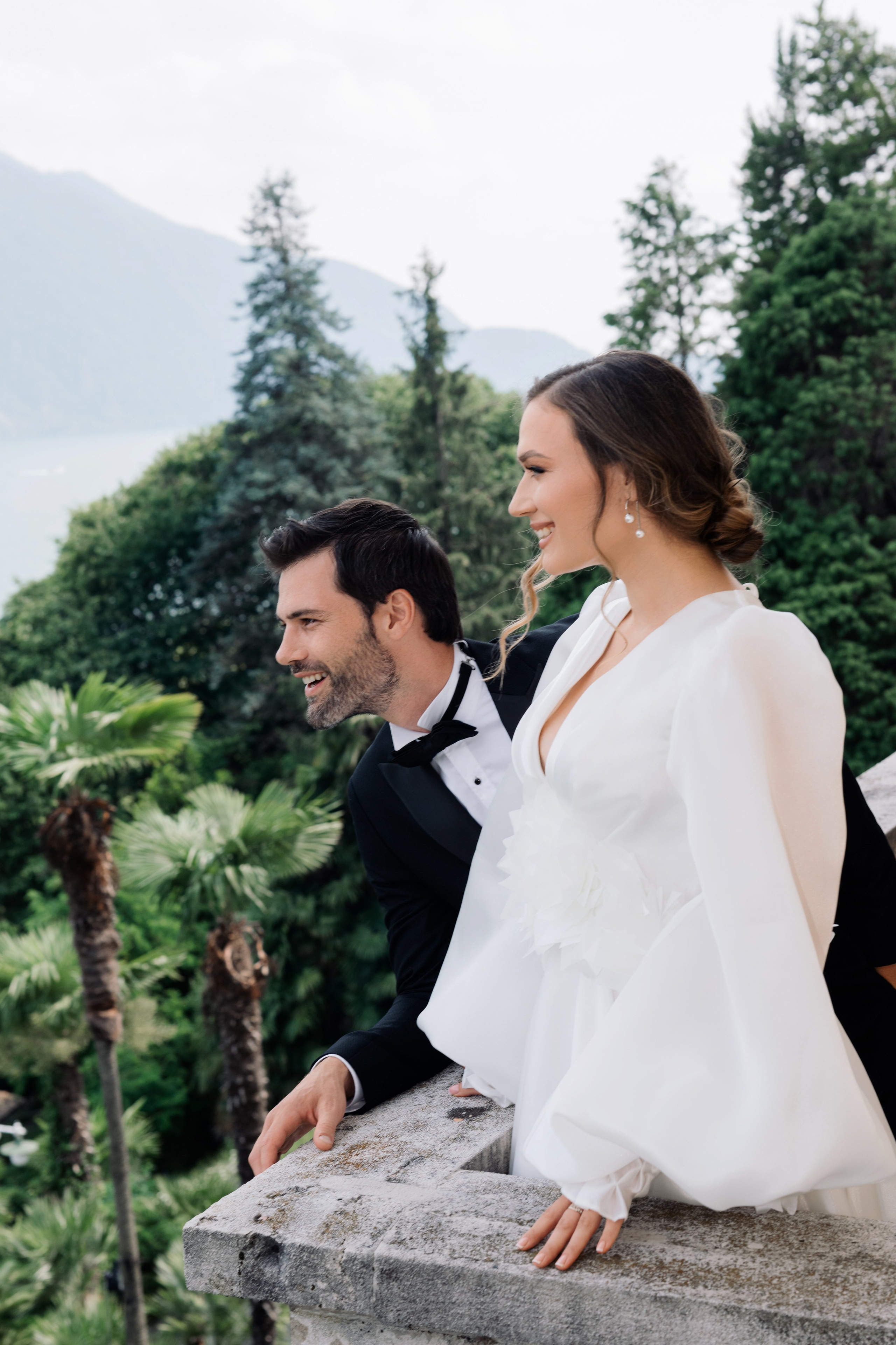 a bride and groom sitting on a ledge