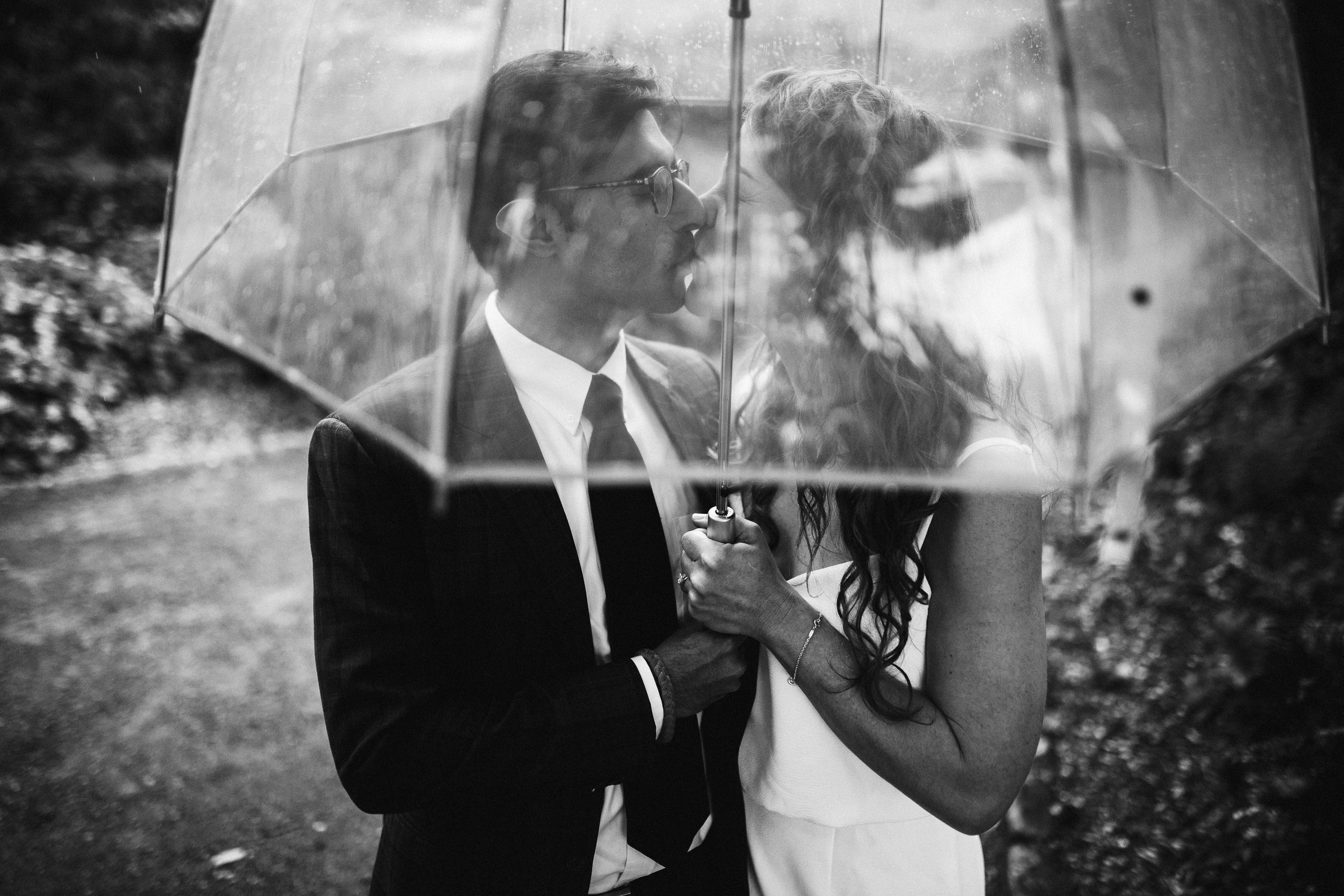 Bride and groom under umbrella, black and white romantic photo