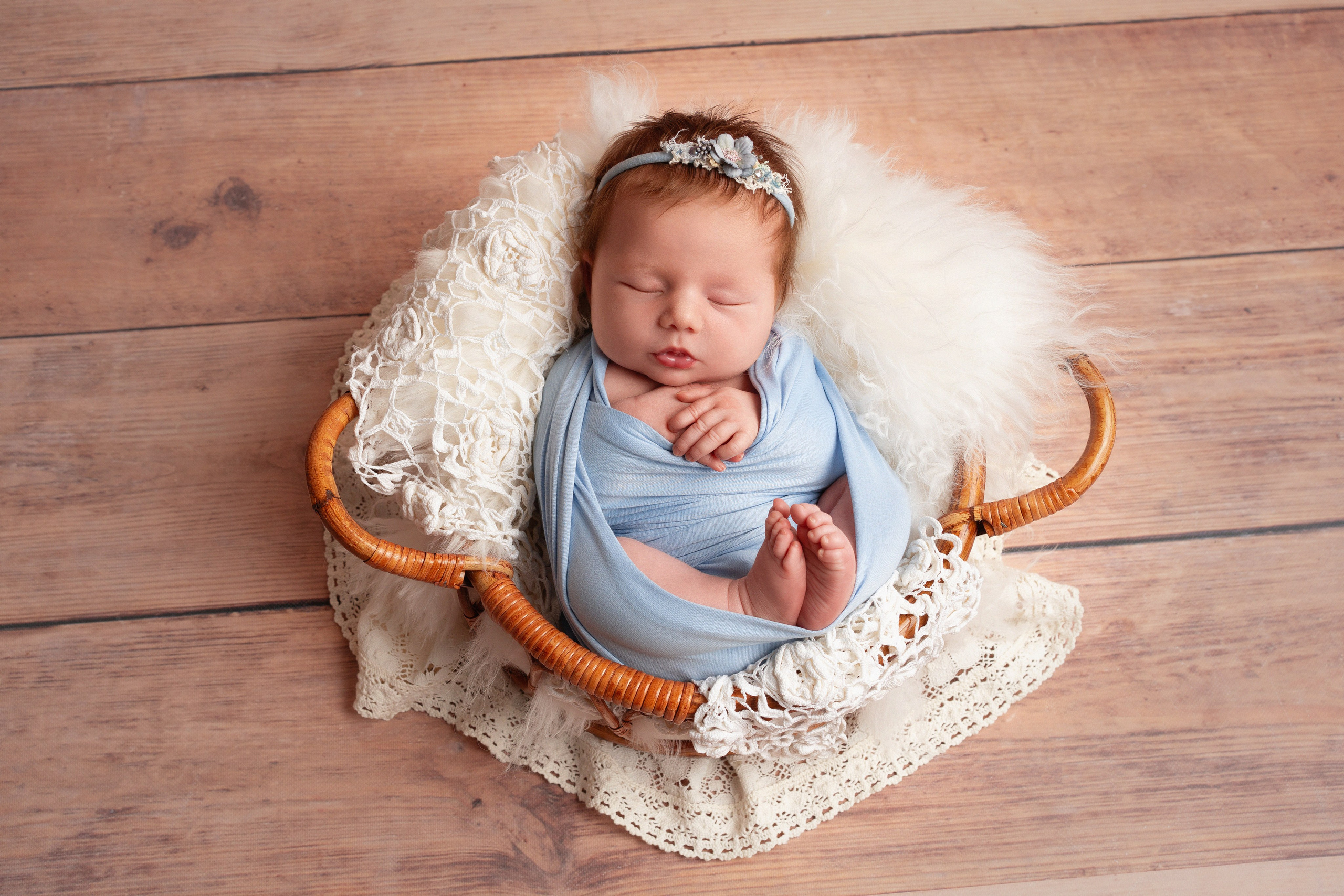 Neugeborenes Baby in süßem Outfit auf Decke fotografiert