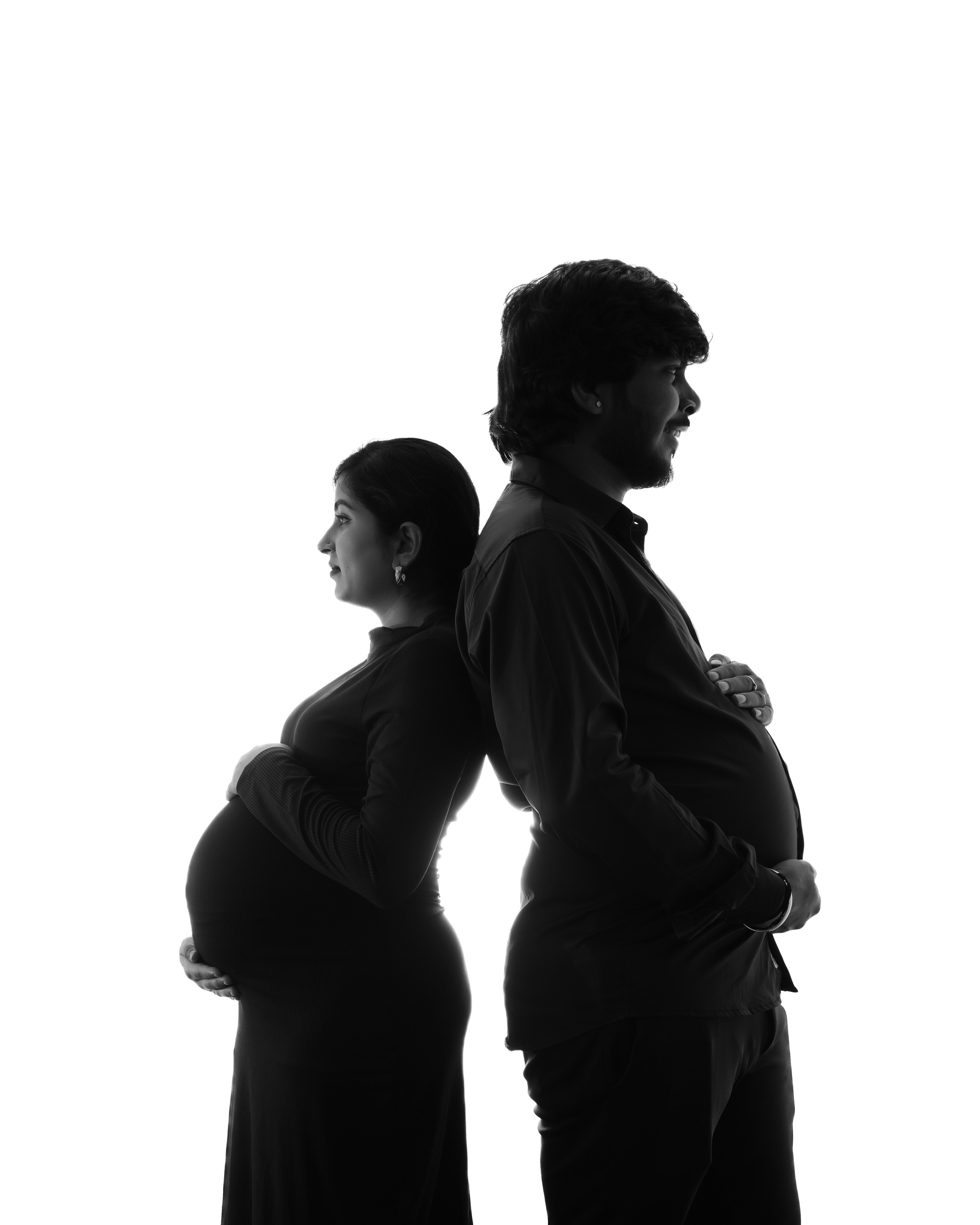 black and white studio silhouette portrait of a pregnant couple standing back to back in Malleshwaram, Bengaluru