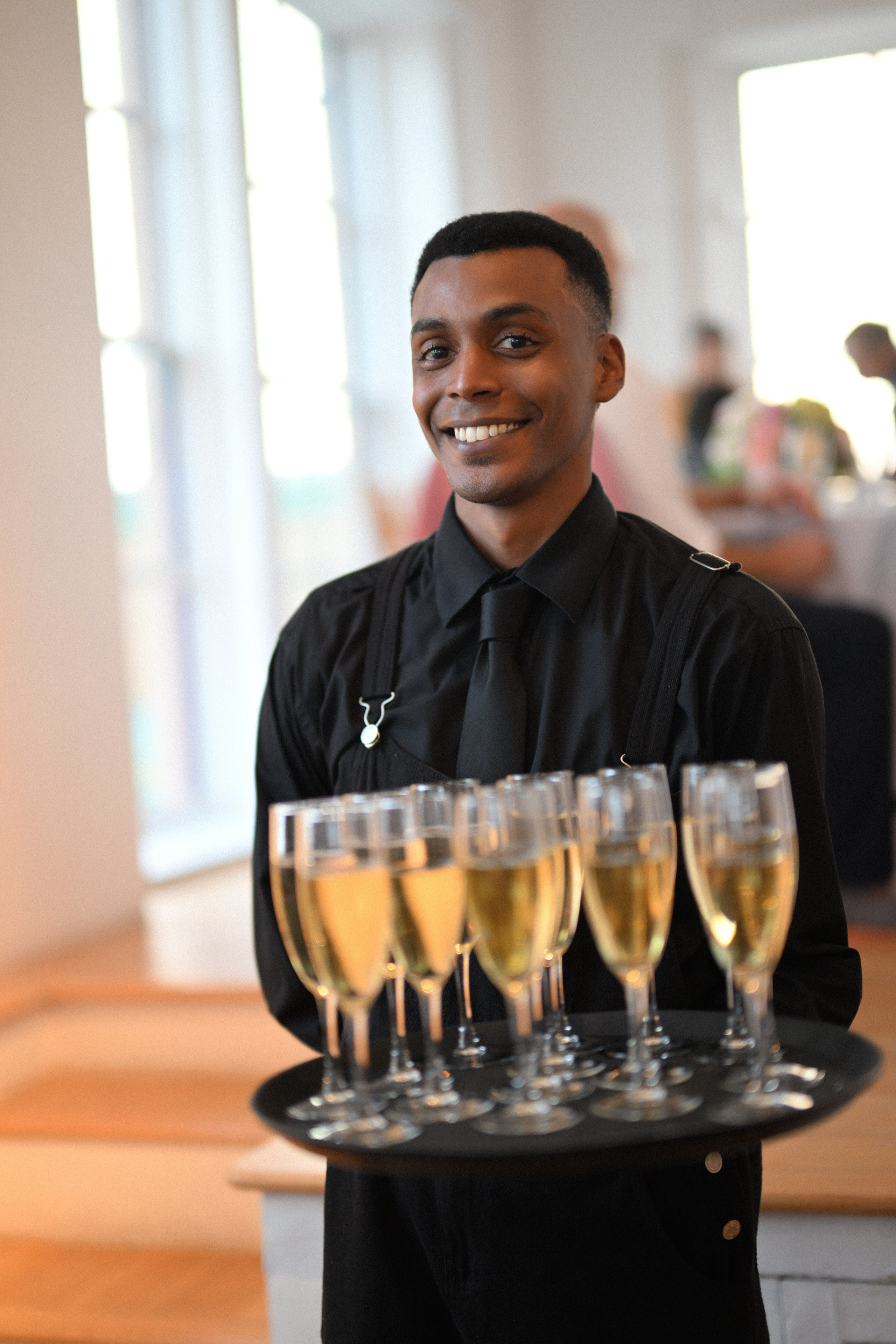 a man holding a tray of champagne glasses