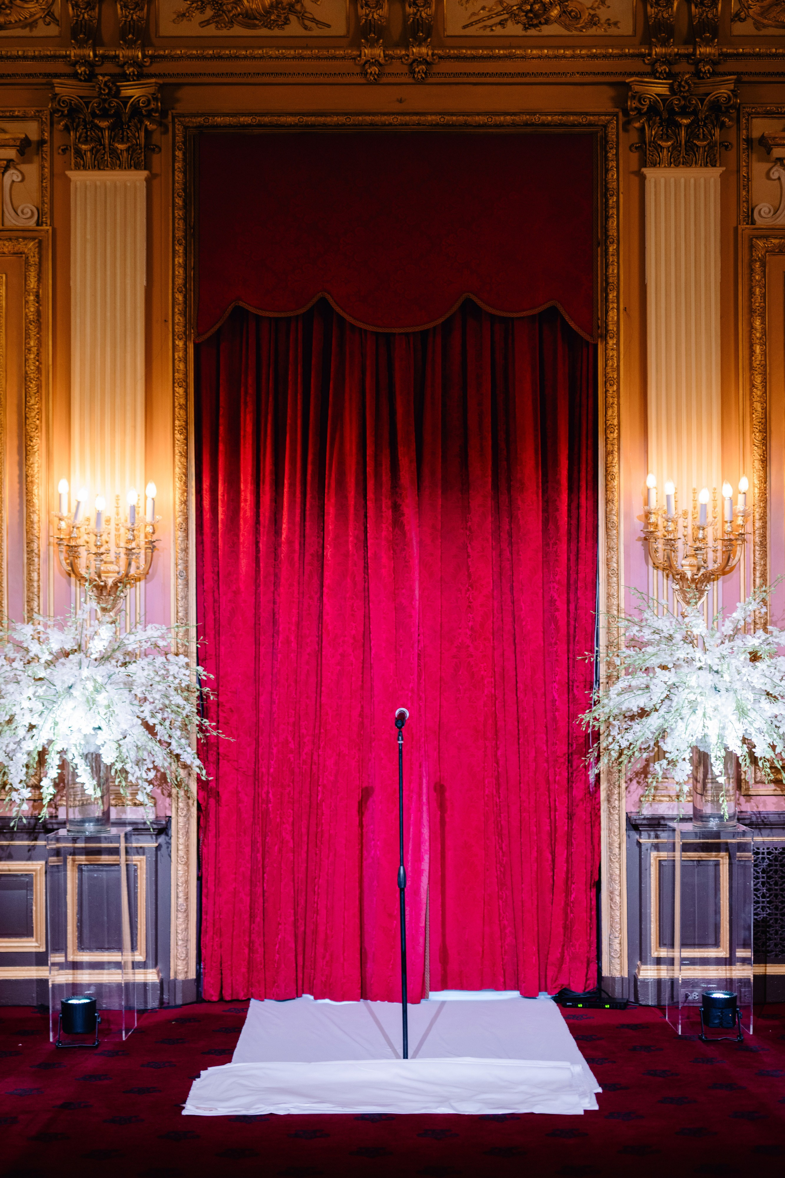 a red stage with a white flower arrangement