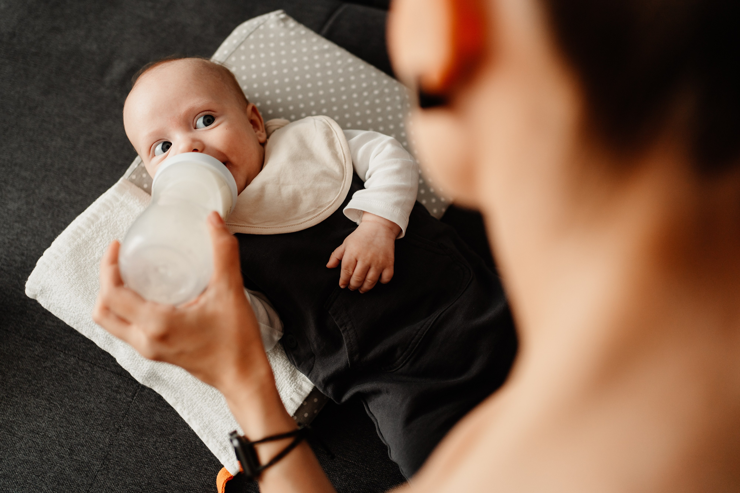 Instantaneu plin de tandrețe dintre părinți și bebeluș în ziua botezului, realizat în Craiova. Fotografie profesională de botez, capturând emoțiile autentice ale familiei într-un decor luminos și cald