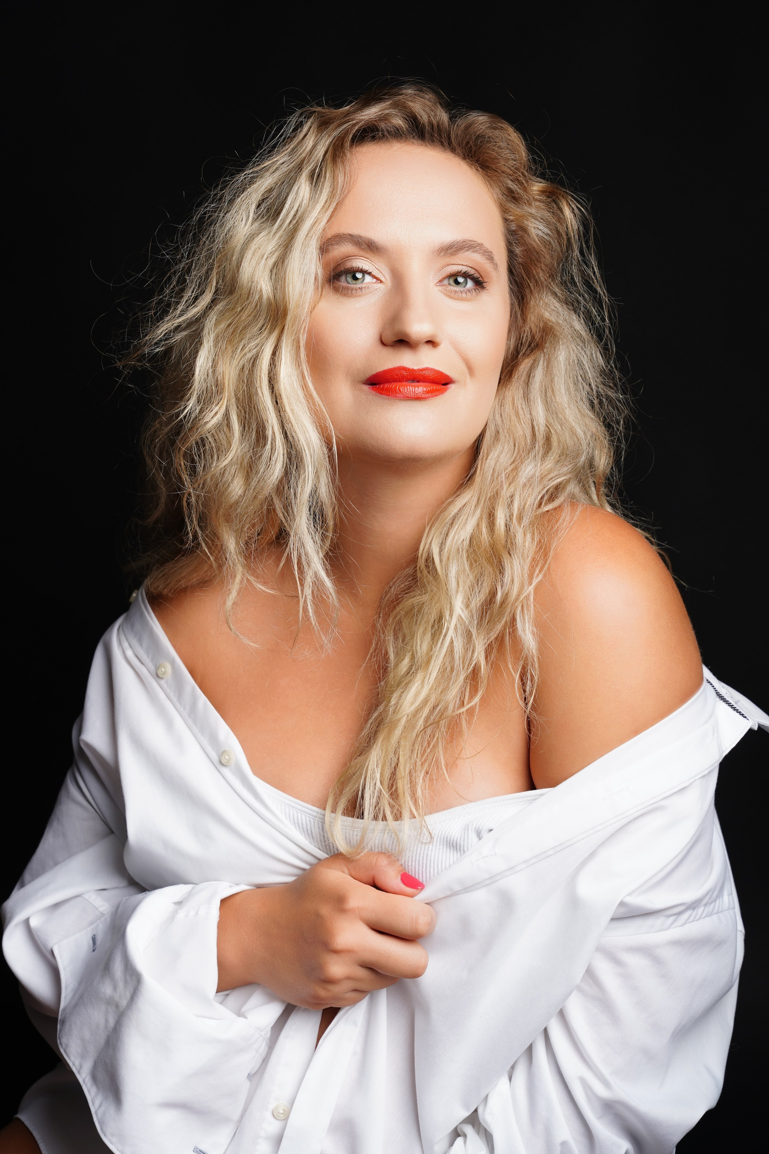 Fröhliches Porträt einer schwangeren Frau im lockeren weißen Hemd – Fotostudio Augsburg