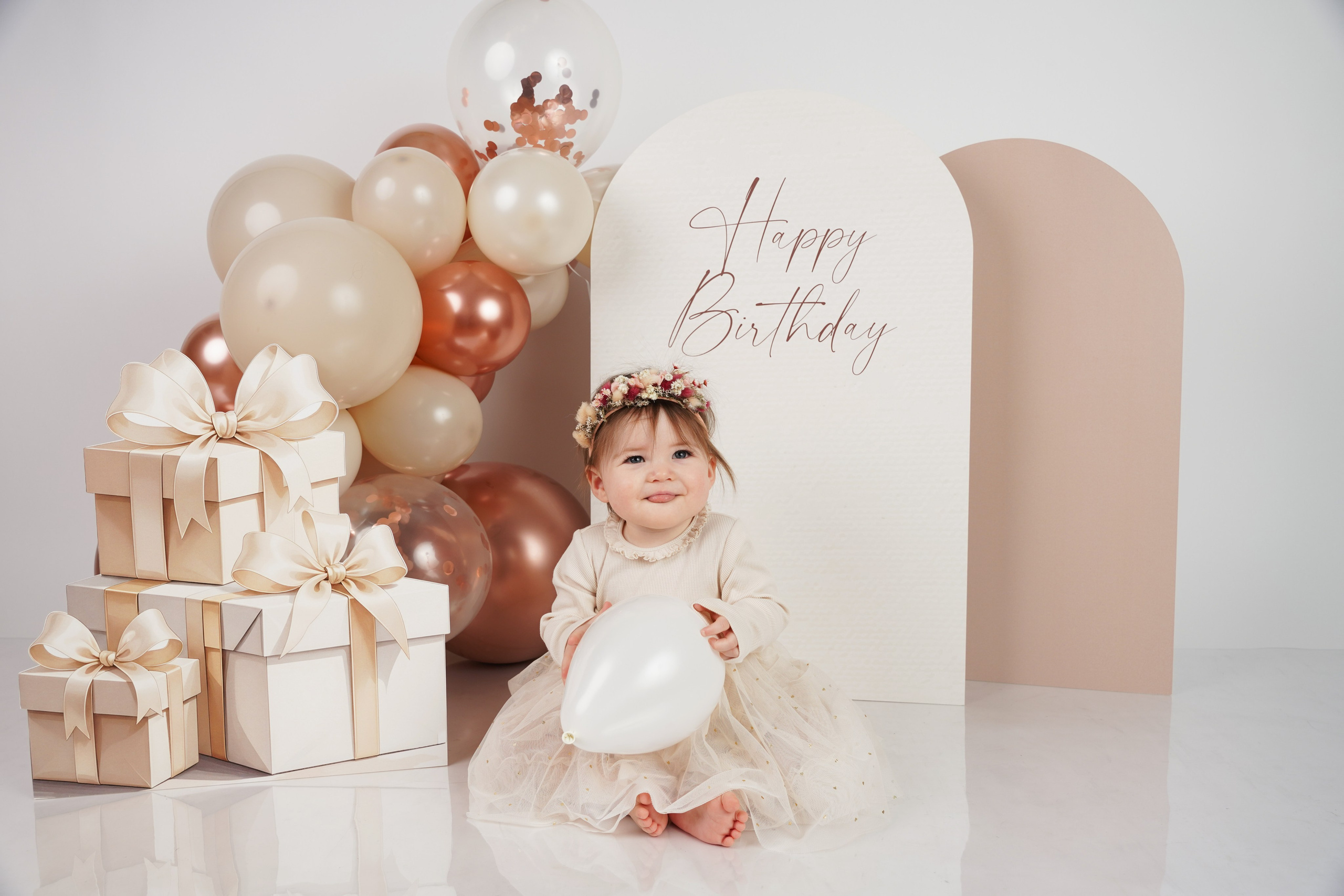Erster Geburtstag Fotoshooting in Augsburg: Kleines Mädchen in beiger Ballon-Kulisse mit Geschenken