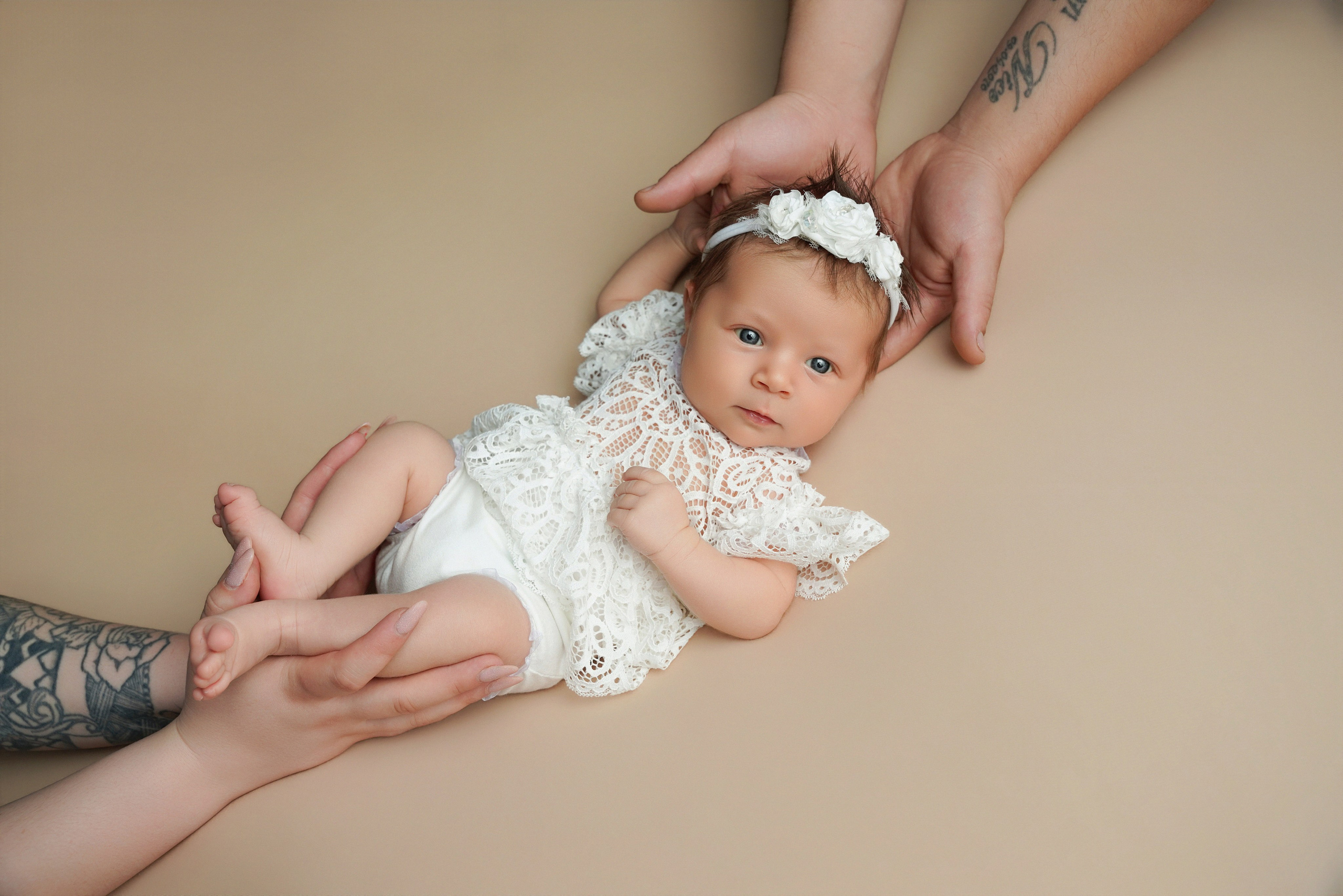 Neugeborenes Mädchen eingewickelt in den Elternhaenden im Fotostudio Gersthofen