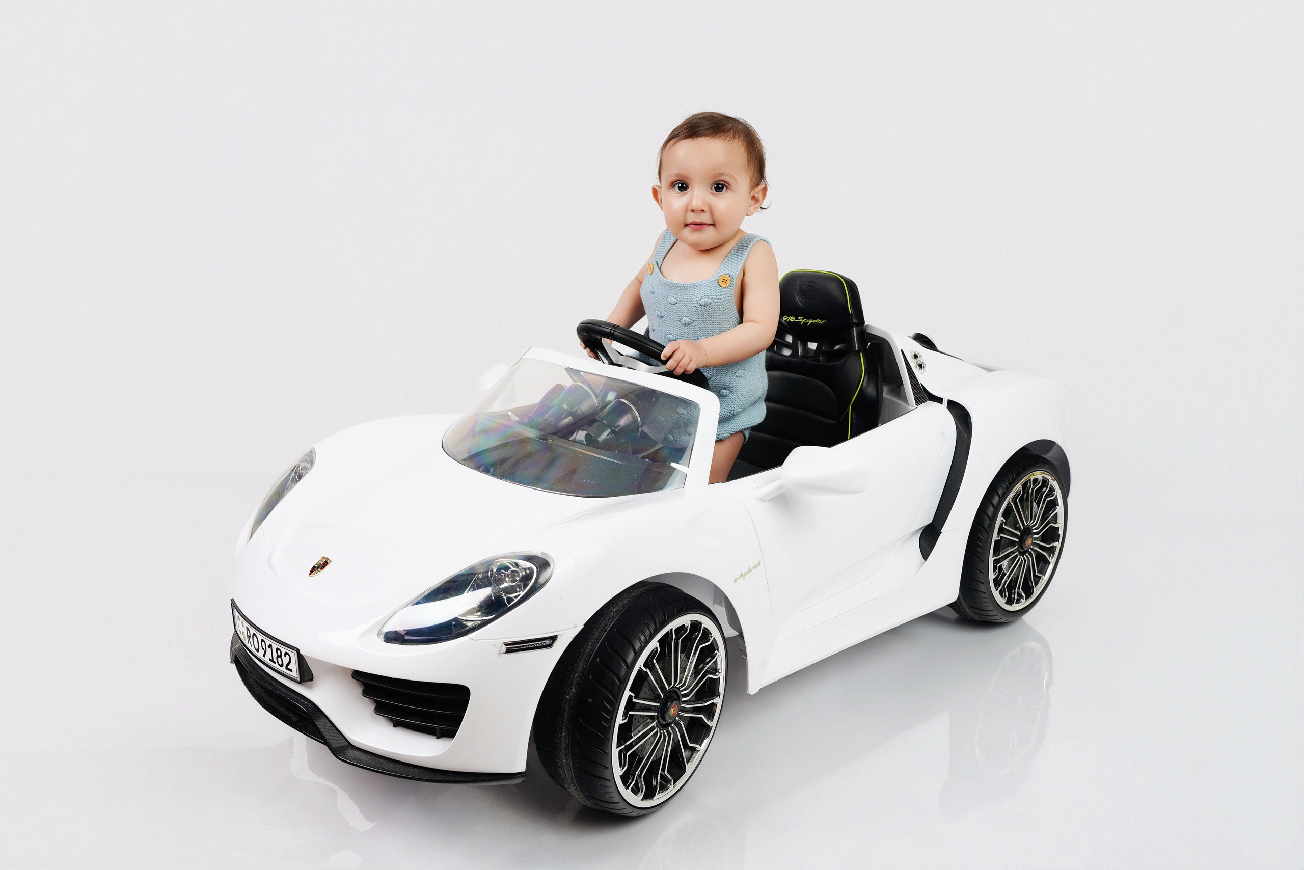 Kleines Kind fährt weißes Kinder-Elektroauto beim Studio-Fotoshooting in Gersthofen