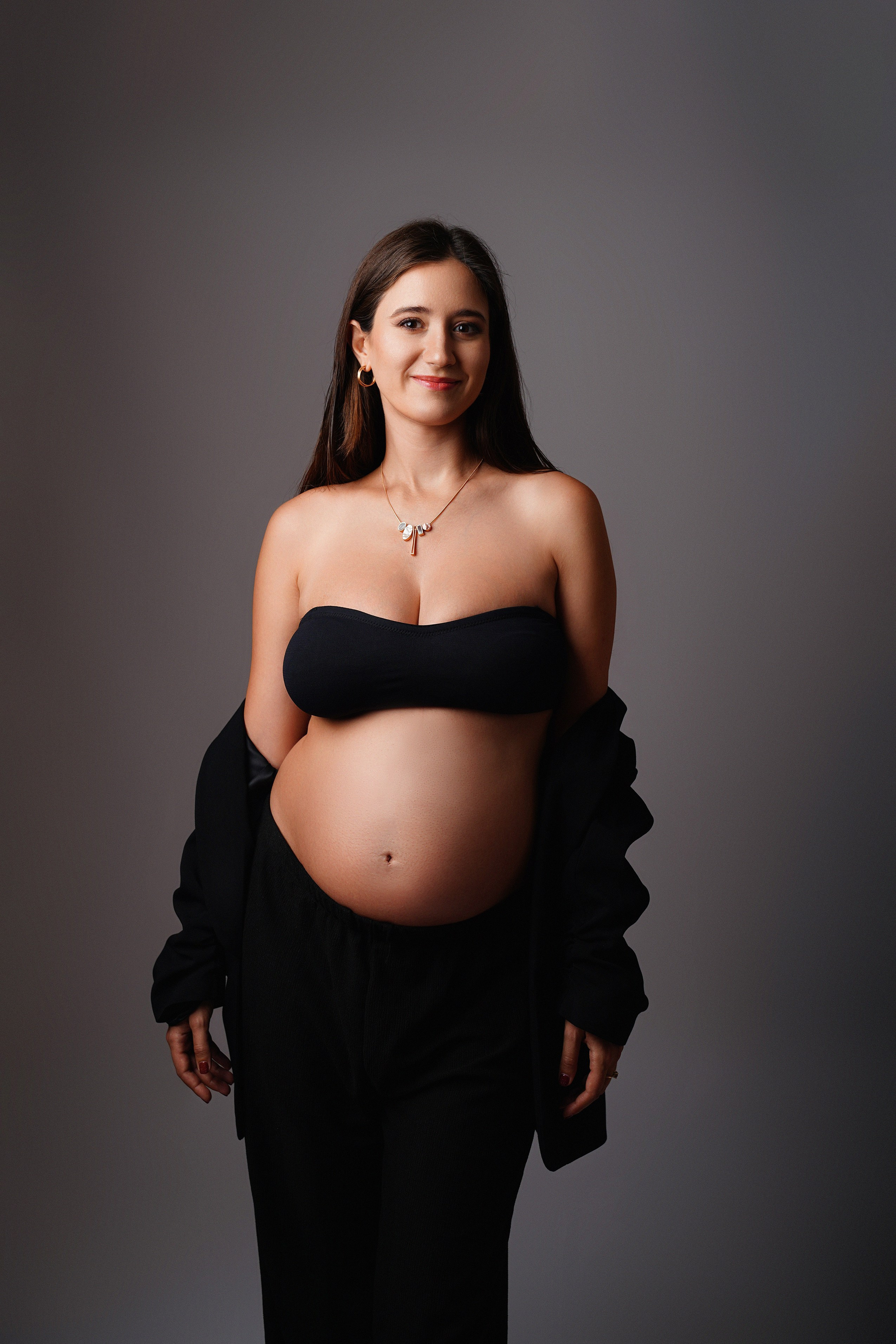 Schwangere Frau im stilvollen schwarzen Zweiteiler beim Maternity-Shooting in Augsburg