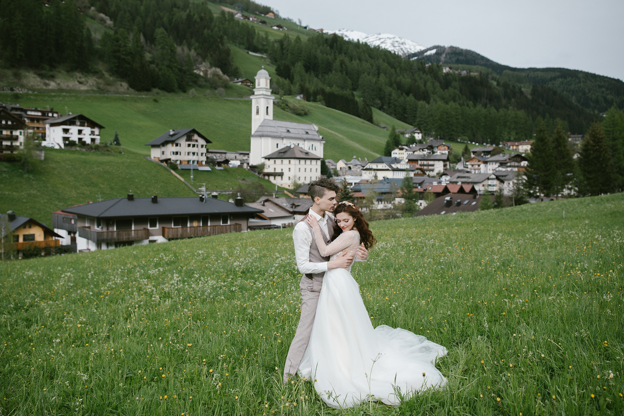 Hochzeitspaar umarmt sich im Dolomiten-Bergdorf