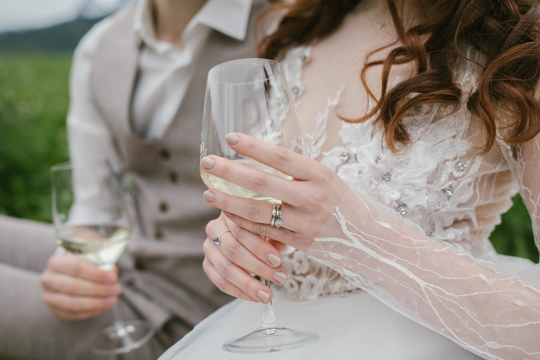 Braut hält Weinglas beim Dolomitenpicknick