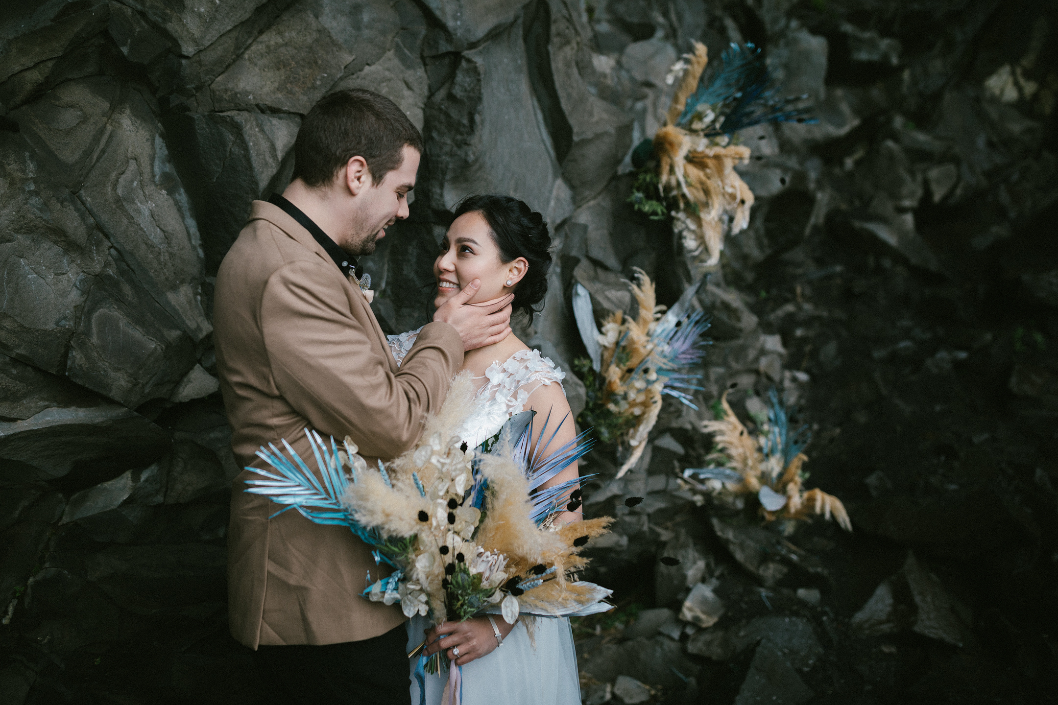 Bräutigam hält Braut an Basaltfelsen, Vik