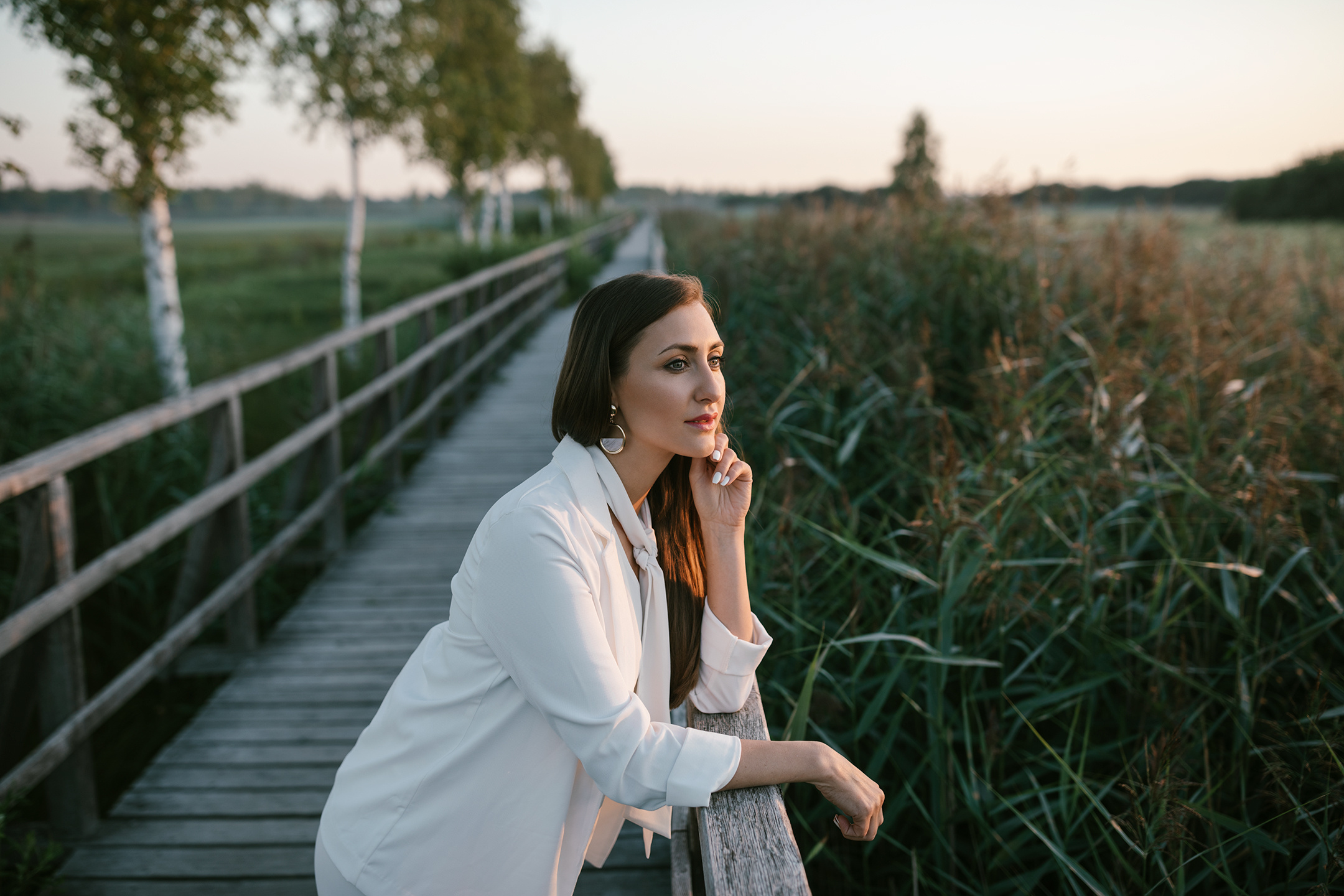 Elegantes Frauenportrait auf dem Federseesteg bei goldenem Sonnenlicht