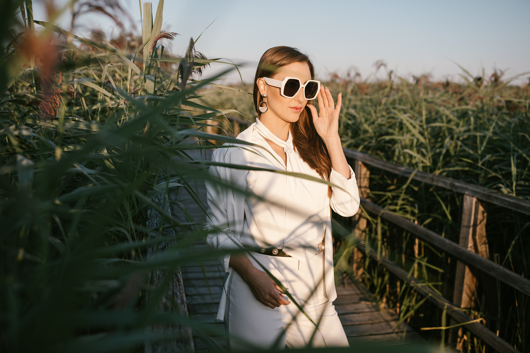 Modefotoshooting auf Holzbrücke zwischen hohem Schilf am Federsee