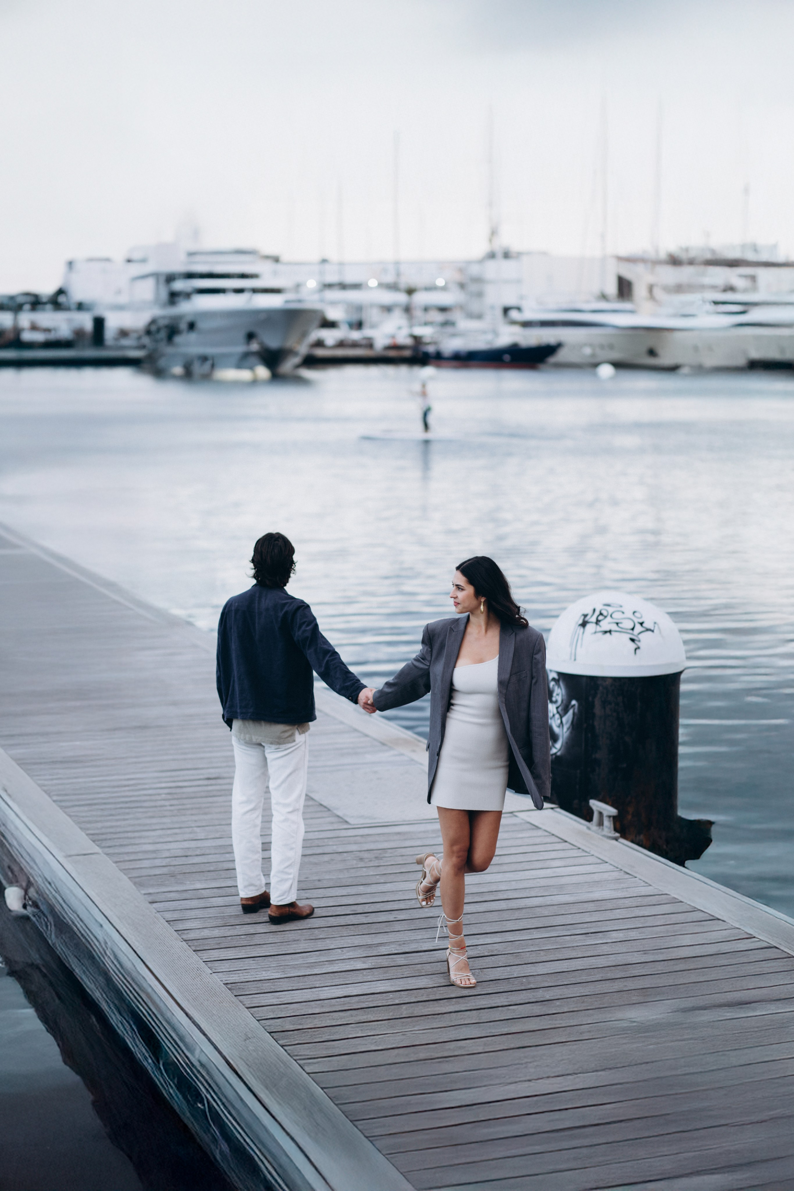 Romantic couple walking hand in hand along the marina in Málaga, Spain — a serene and stylish love story photoshoot capturing connection, elegance, and coastal charm. Ideal for couples searching for engagement or couple photography sessions in Málaga and the south of Spain.
