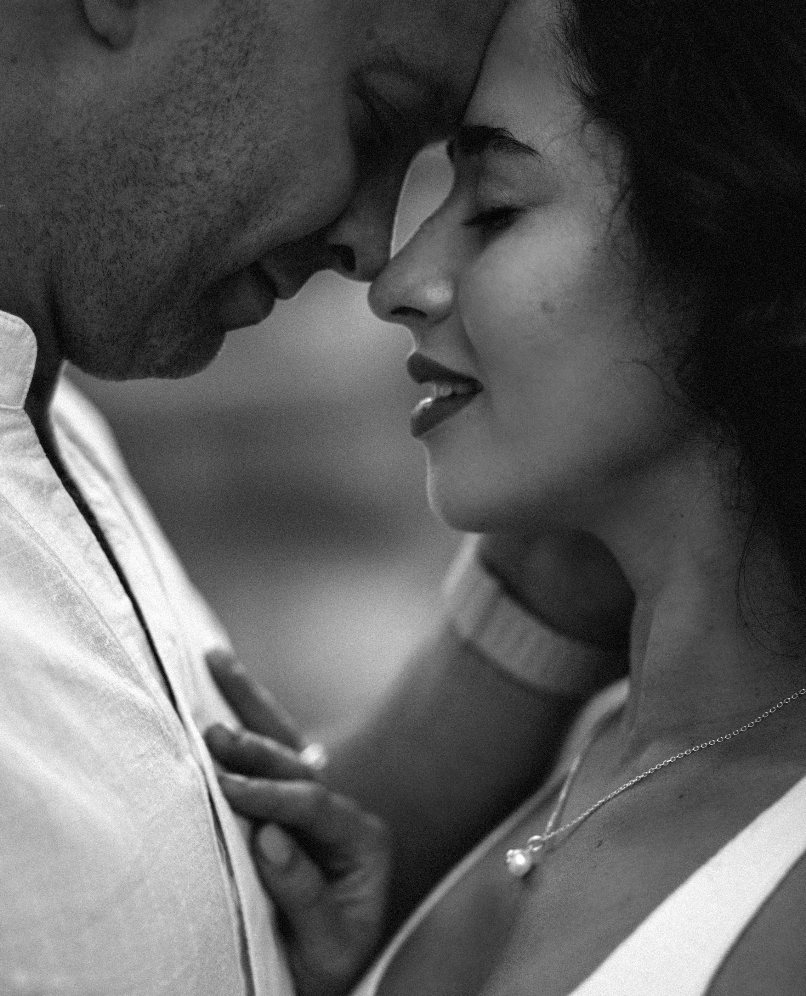 Intimate black and white close-up of a couple embracing tenderly, foreheads touching in a quiet moment of connection, captured during a romantic Love Story session in Valencia, Spain.