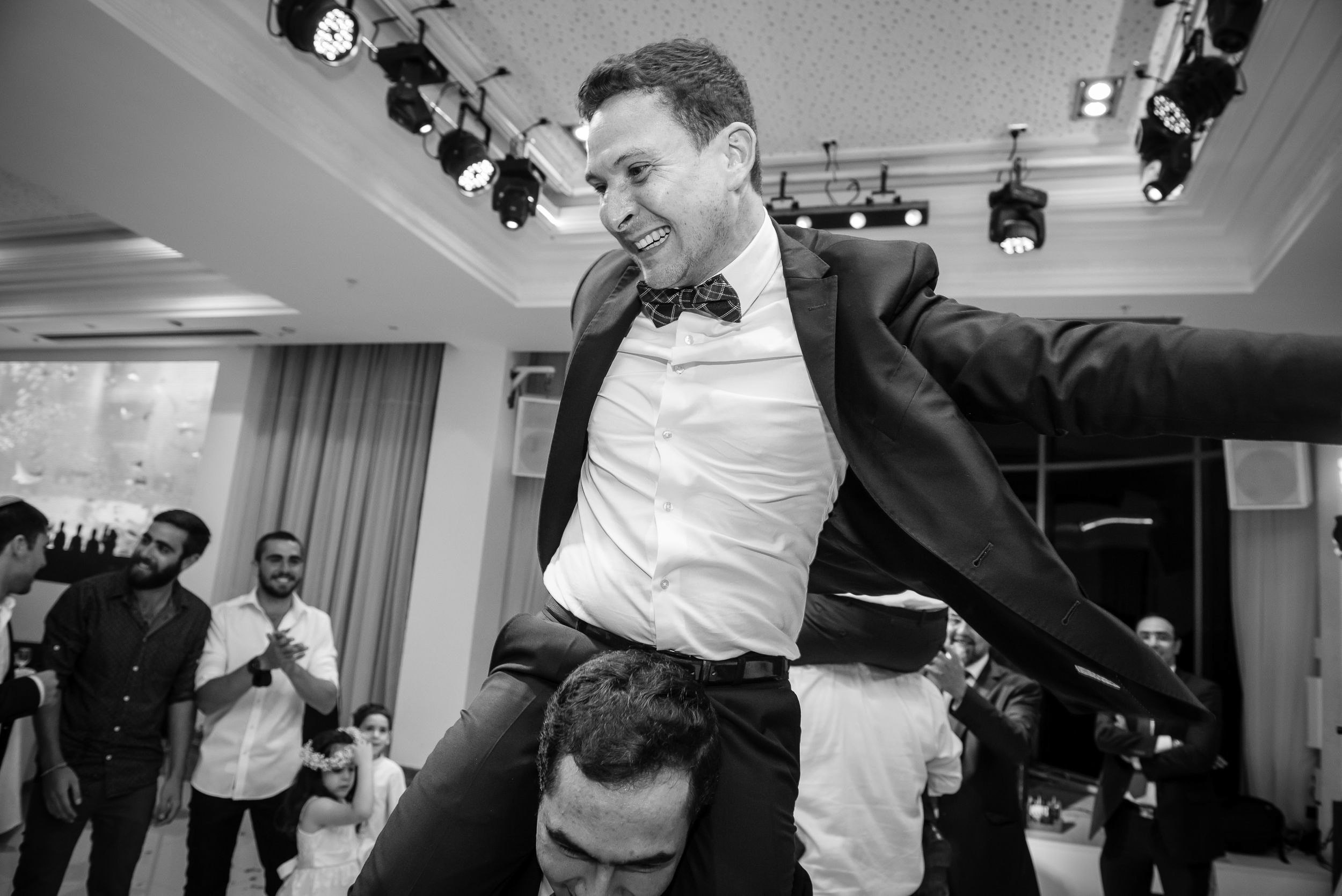Michael's brother dancing on a guest's shoulders during the wedding reception at the Leonardo Hotel in Haifa, Israel