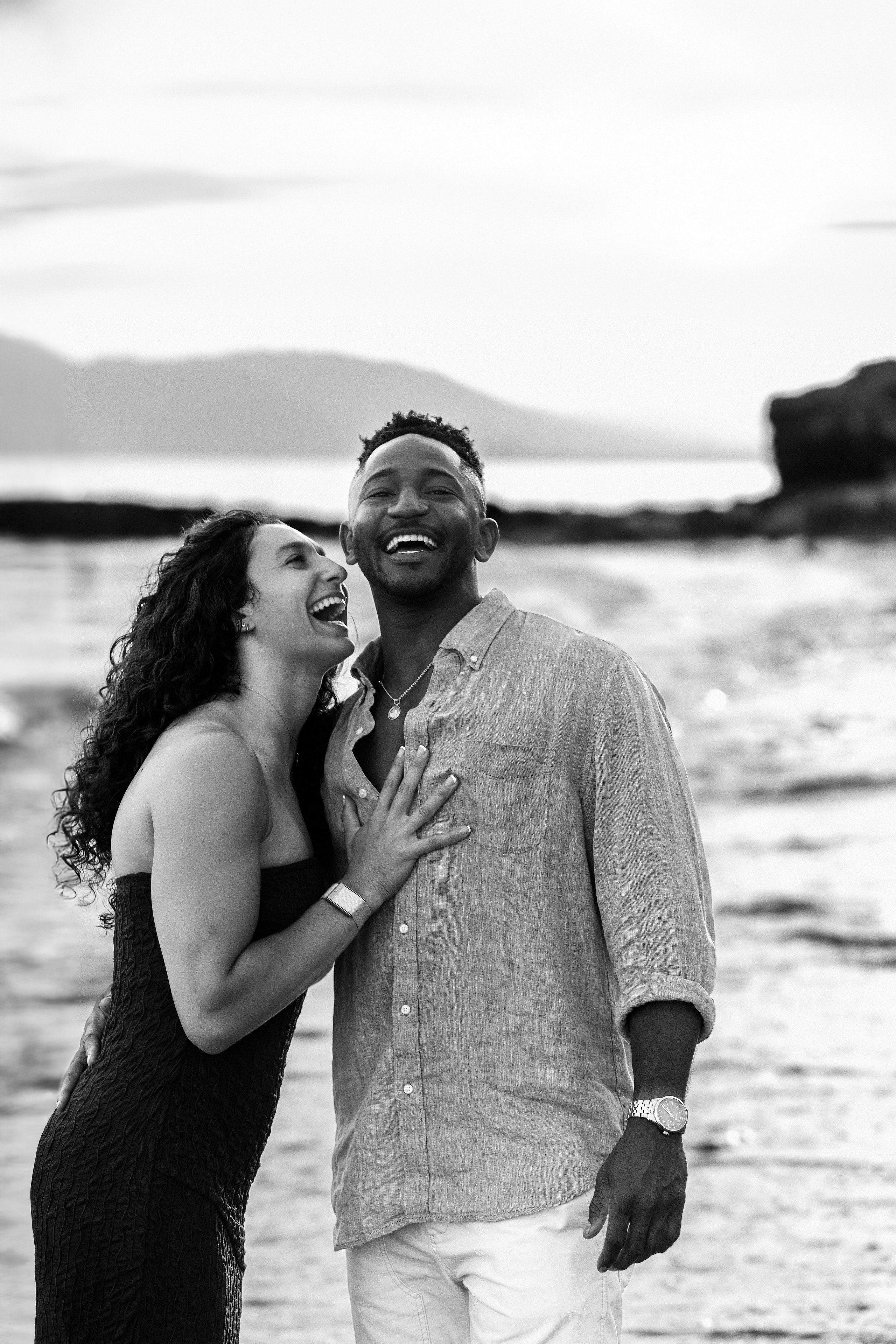 Pareja feliz riendo junta durante una sesión de historia de amor en la playa de Valencia, España — ideal para quienes buscan experiencias fotográficas espontáneas y románticas en Valencia y en toda España.