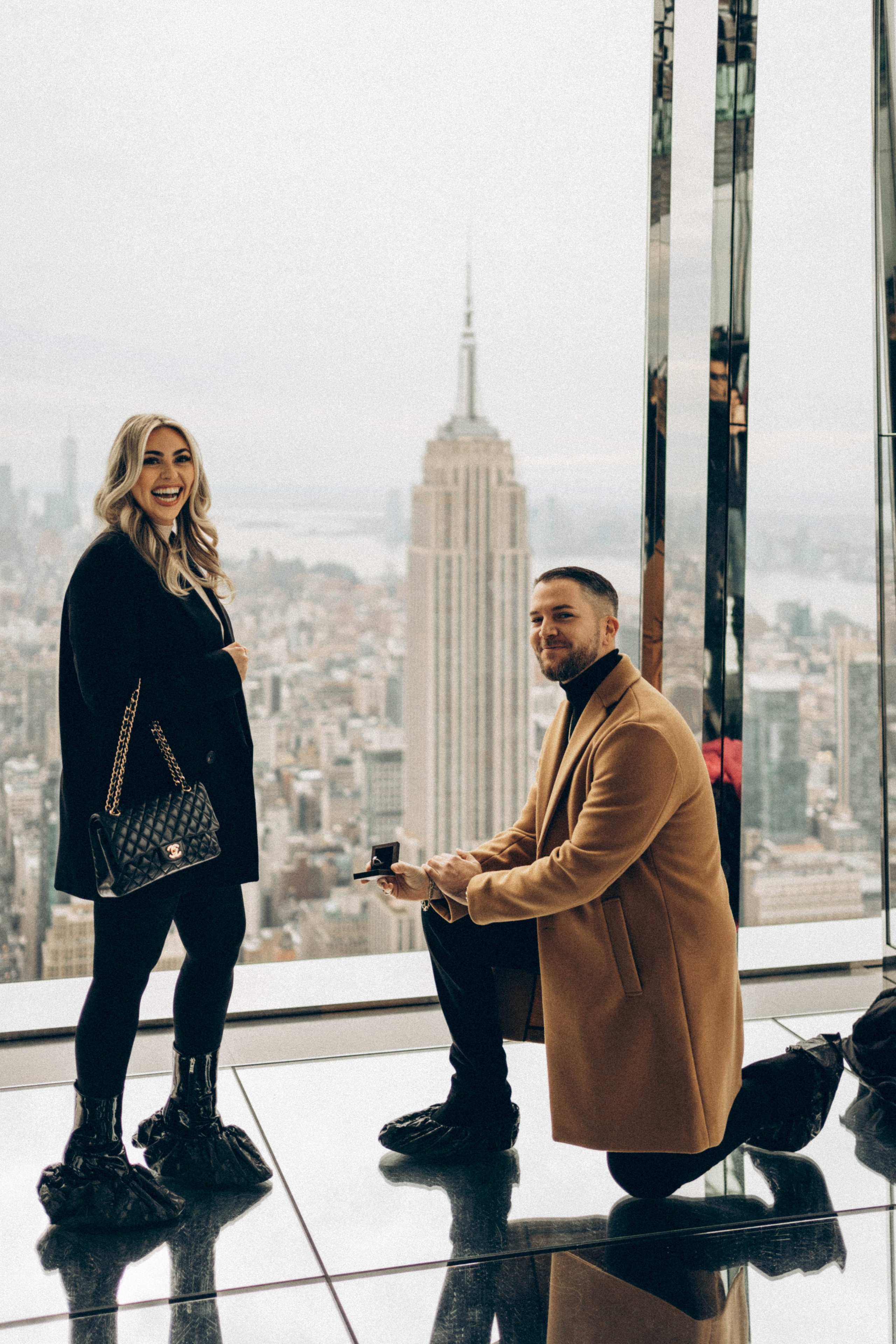 Man proposing with Manhattan Bridge in background.