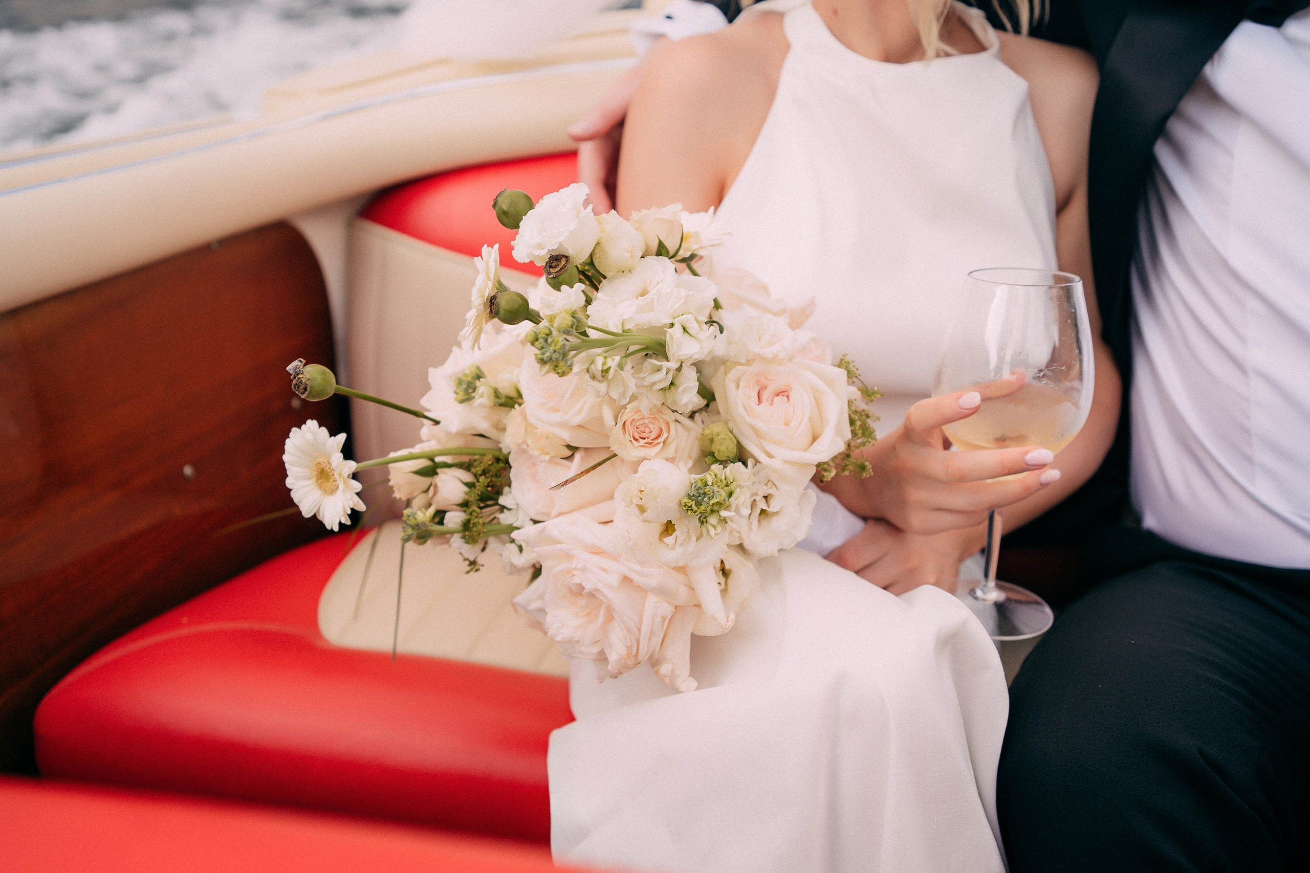 Bride holding her bouquet on the boat at Villa Lario, Lake Como, Italy