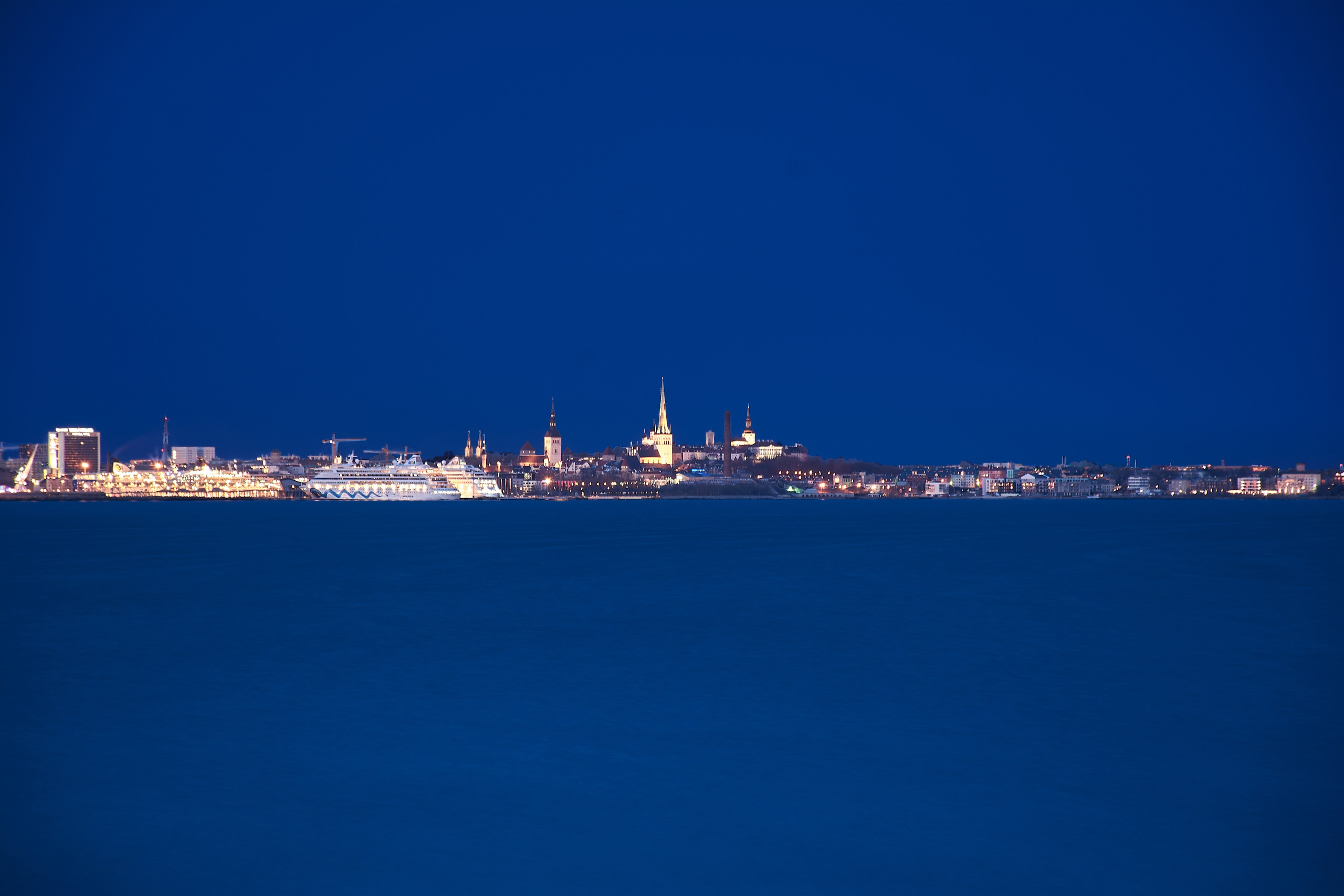 Tallinn medieval skyline glowing across night sea